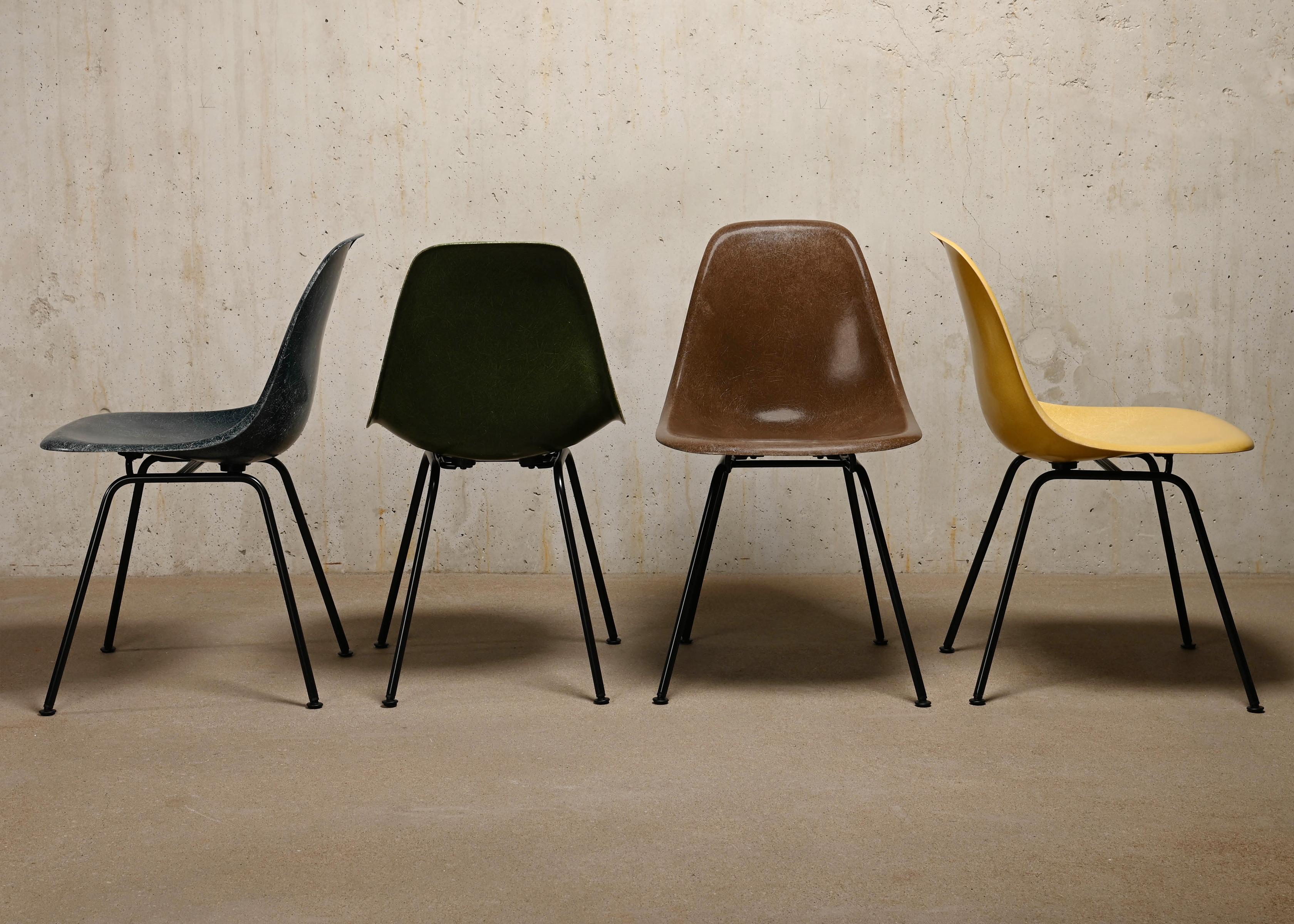 Iconic side chairs designed by Charles and Ray Eames for Herman Miller. Molded fiberglass shells in the colours: Navy Blue, Ochre Light, Seal Brown and Olive Green Dark. Assembled on newly powder coated bases in basic dark. The chairs are in very