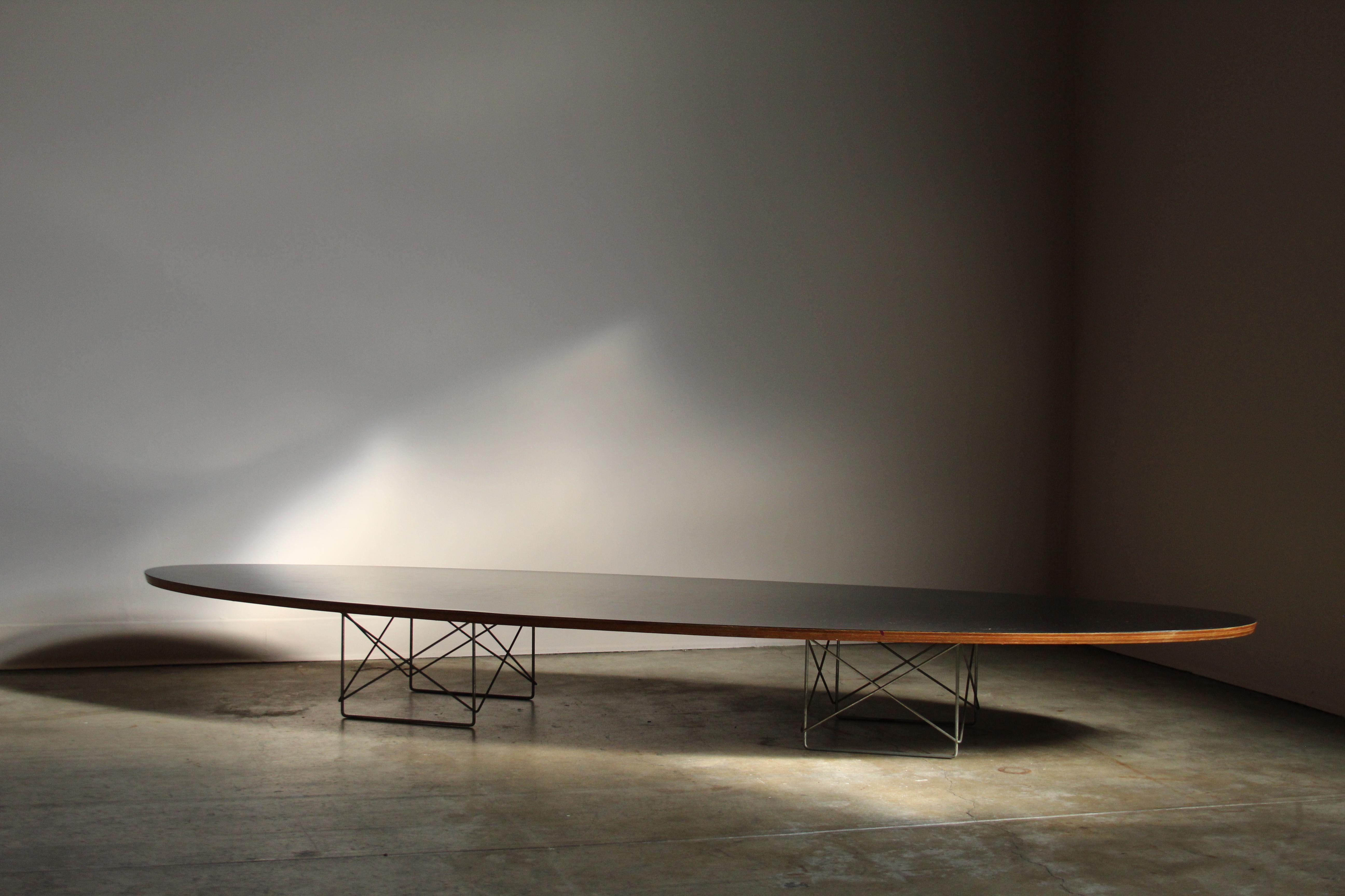 An early and rare edition of the 'ETR' (Elliptical Table Rod base) known as the 'Surfboard' coffee table. Design by Charles & Ray Eames in 1951 for Herman Miller. Black laminated table top. Unlike the later editions with the regular plywood