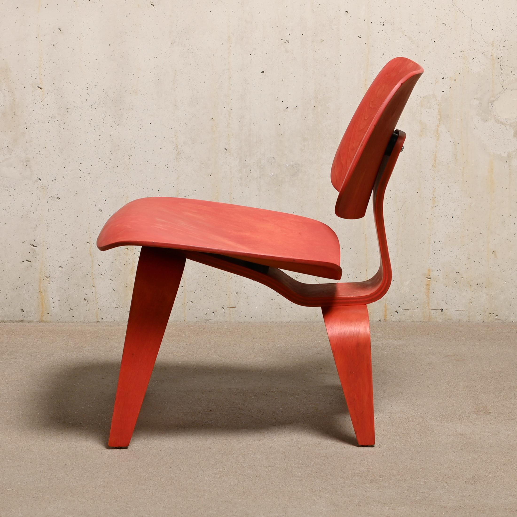 Fauteuil LCW iconique conçu par Charles et Ray Eames en contreplaqué d'érable teinté à l'aniline rouge. Le placage et la chaise sont en très bon état vintage avec de petits signes de vieillissement et d'usure. Première édition d'Herman Miller après