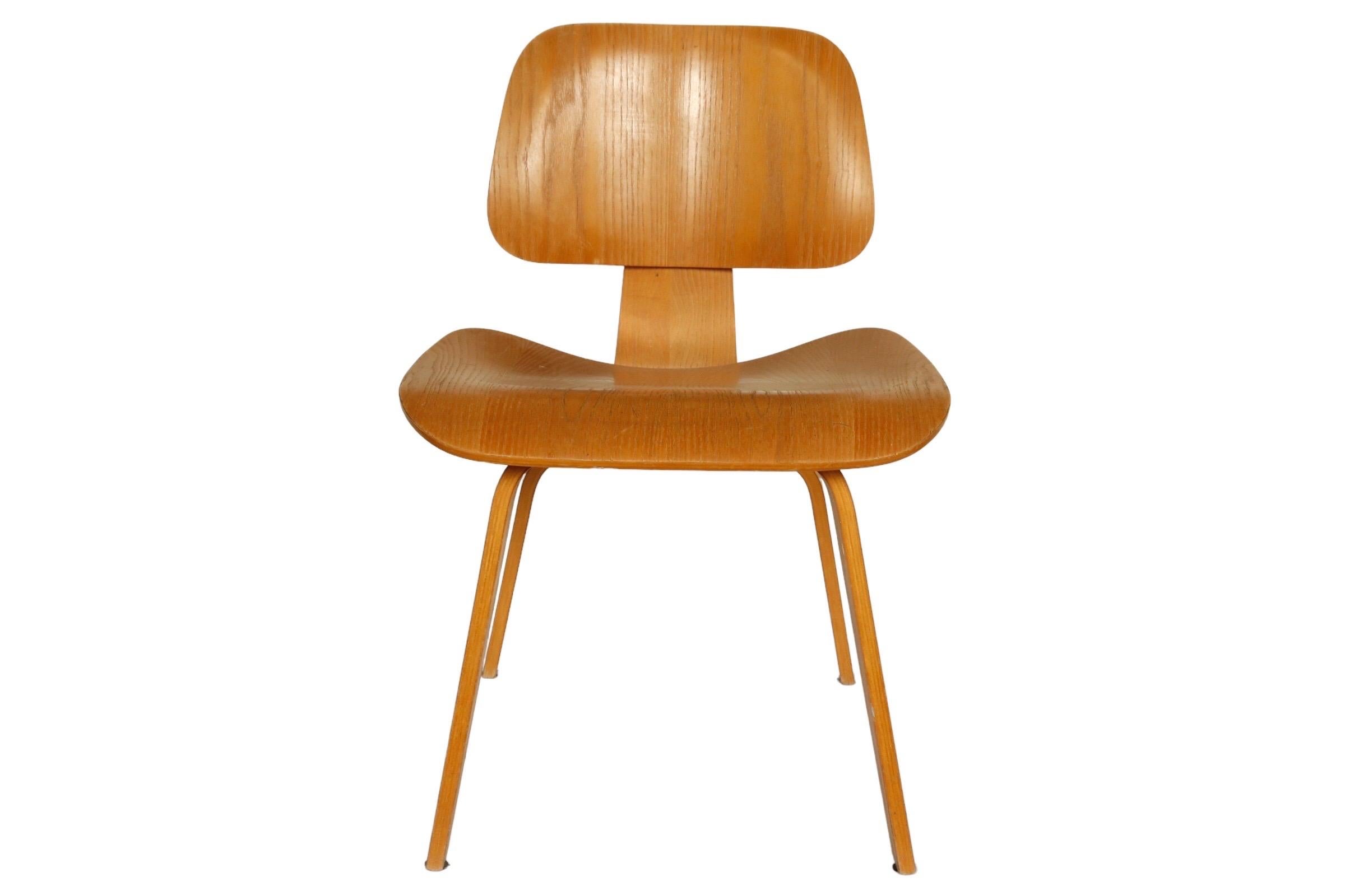 A pair of vintage original DCW chairs, designed by Charles and Ray Eames for Herman Miller. 

Early 21st century.

Molded plywood in a signature profile.

Legs and seat edges are clean with no major chips. Structurally sound shock mounts are