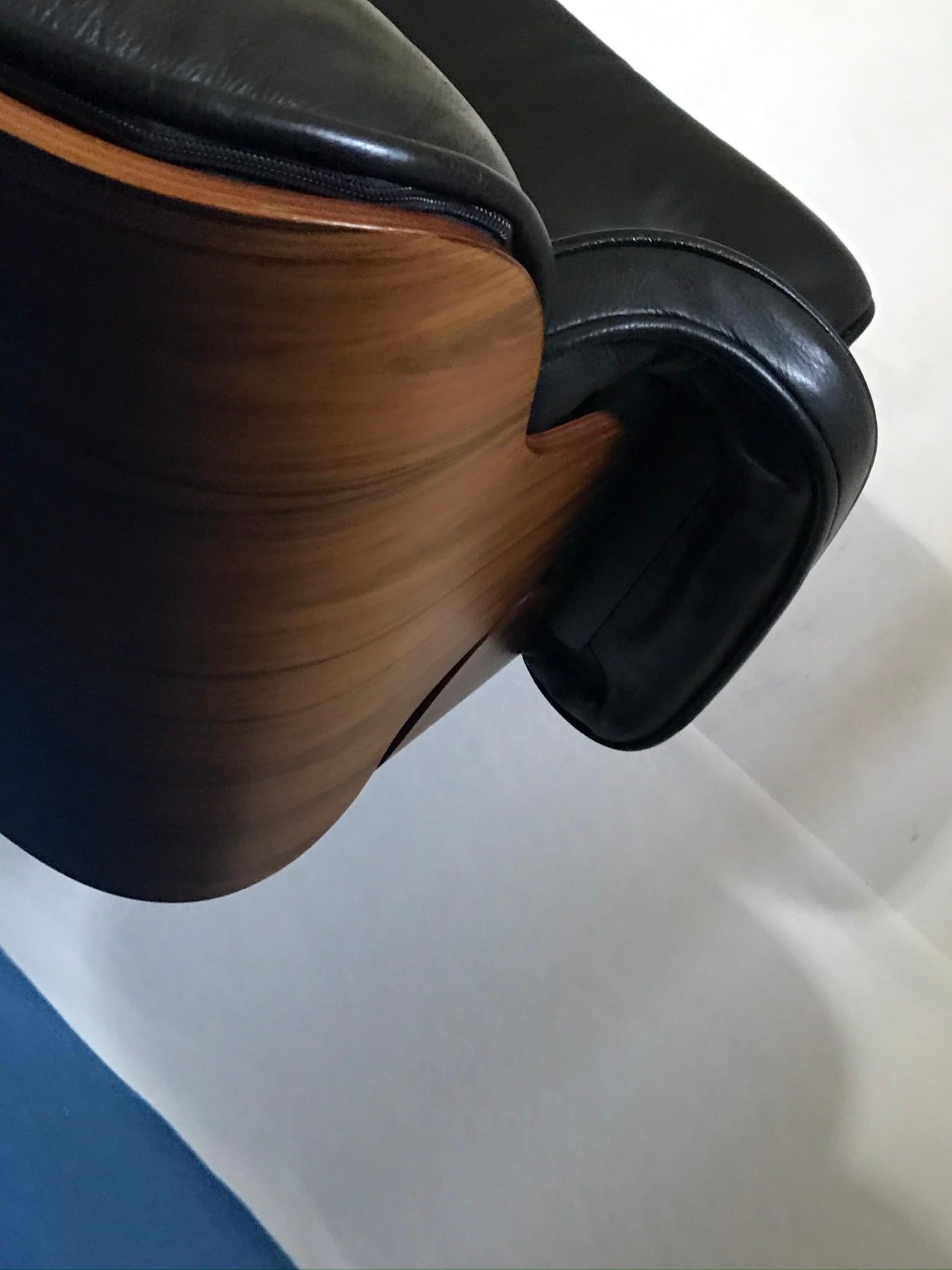 The chair from Charles Eames is made of nut wood and black leather. It is in very nice condition with original patina. A label and a designation were not preseved.