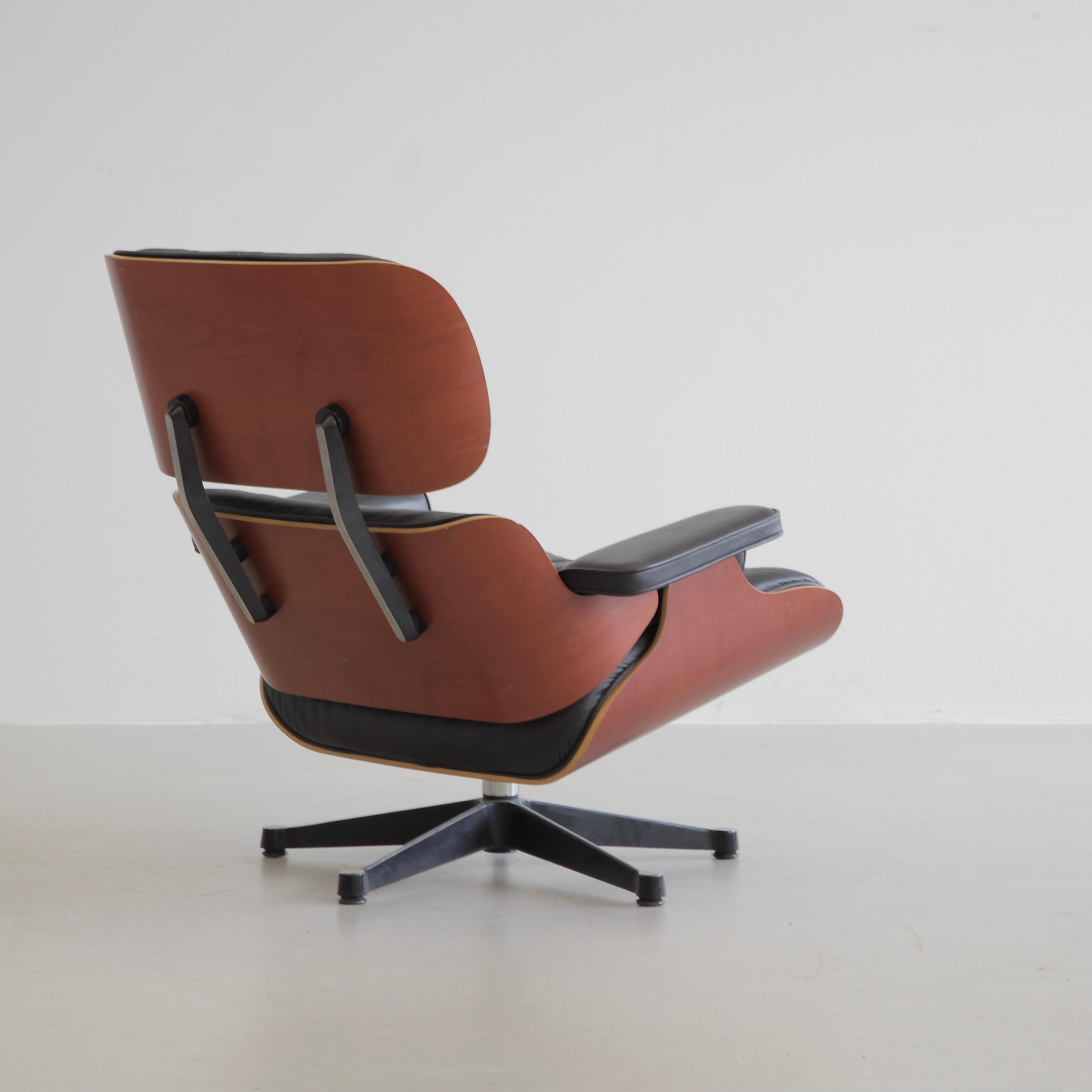 Chaise longue et ottoman, conçus par Charles et Ray Eames en 1956. Allemagne, Vitra, 1999.

Magnifique fauteuil de salon original avec une coque en bois de cerisier et un subtil revêtement en cuir noir. Les étiquettes d'origine du fabricant sont