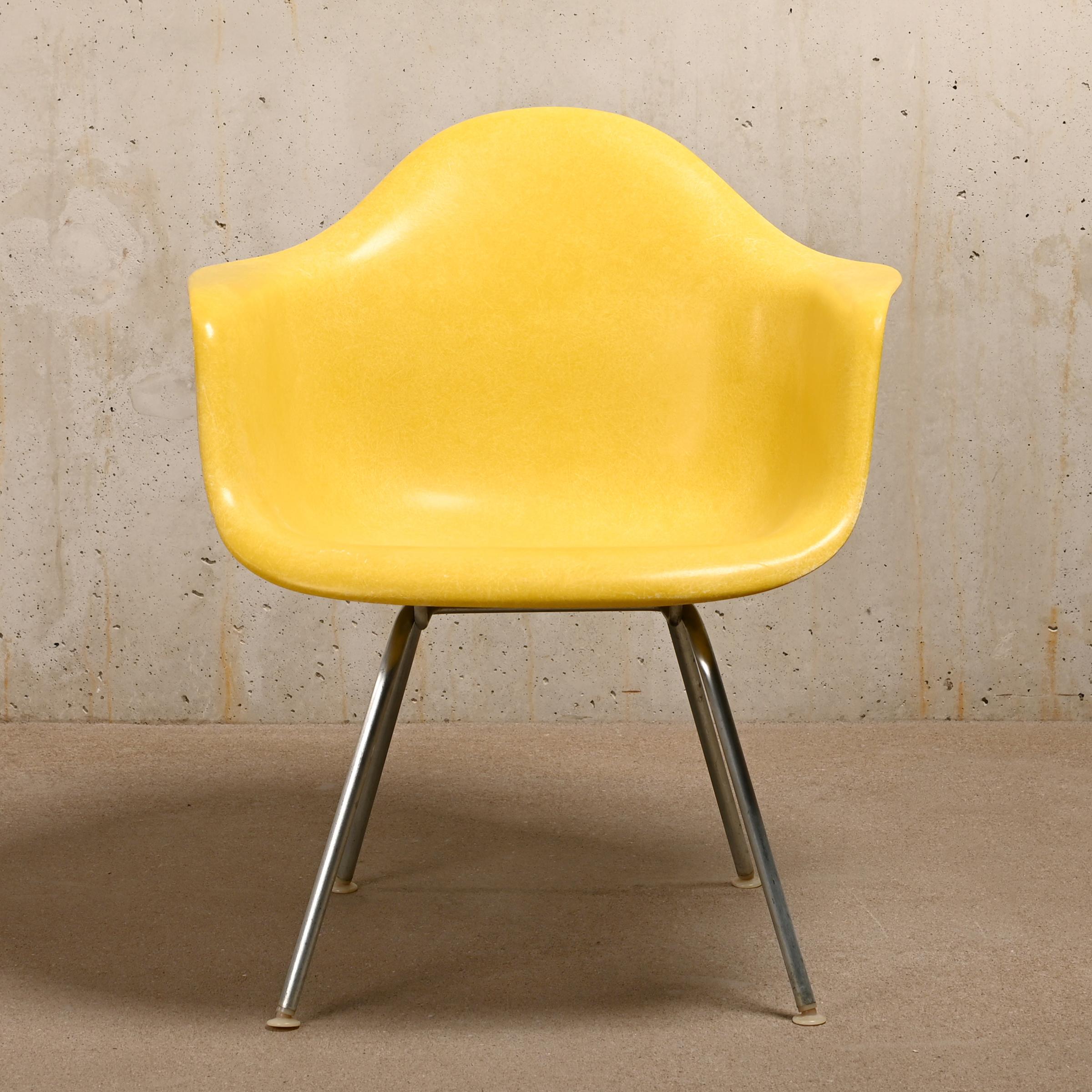 Iconic armchair designed by Charles and Ray Eames for Herman Miller. Molded fiberglass shell in Canary Yellow and assembled on a medium height zinc plated steel H-base (MAX). The chair is in good vintage condition with small signs of wear. The shock