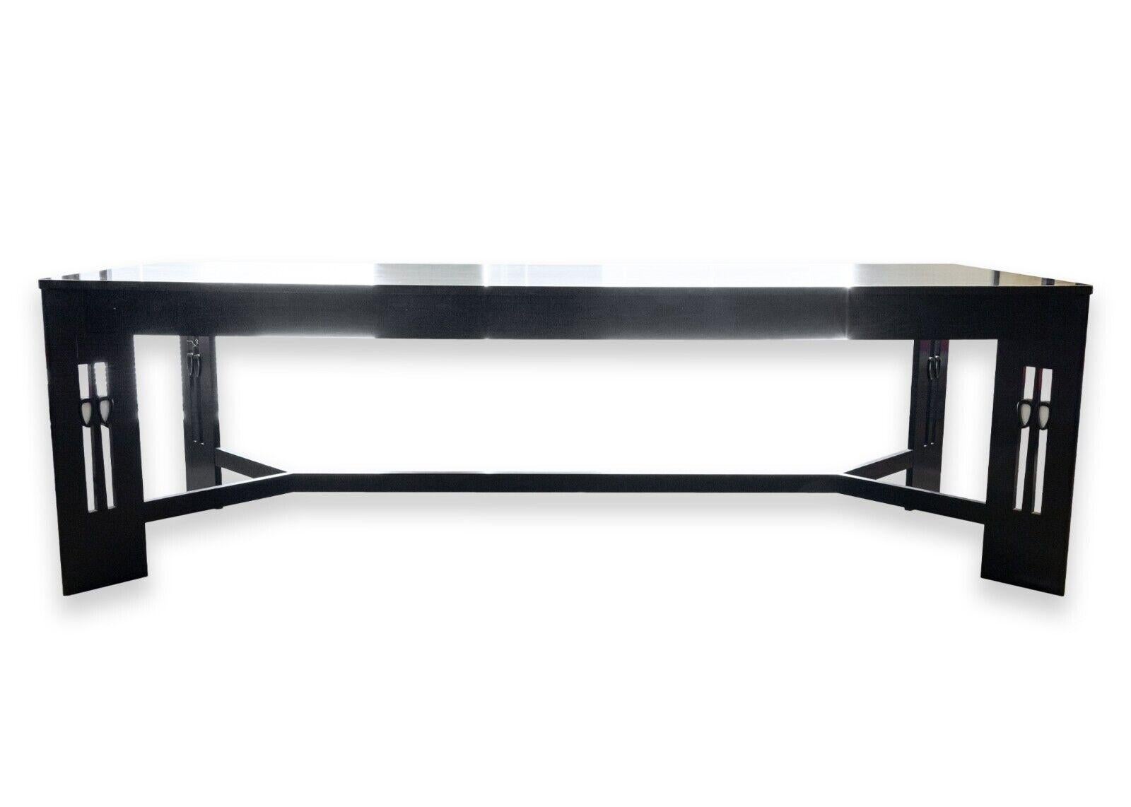 A Charles Rennie Mackintosh black ebonized wood dining table. A gorgeous dining table with a distinct design. This piece designed by Mackintosh features a beautiful black wood construction with lovely wood grain, four slanted legs with diamond
