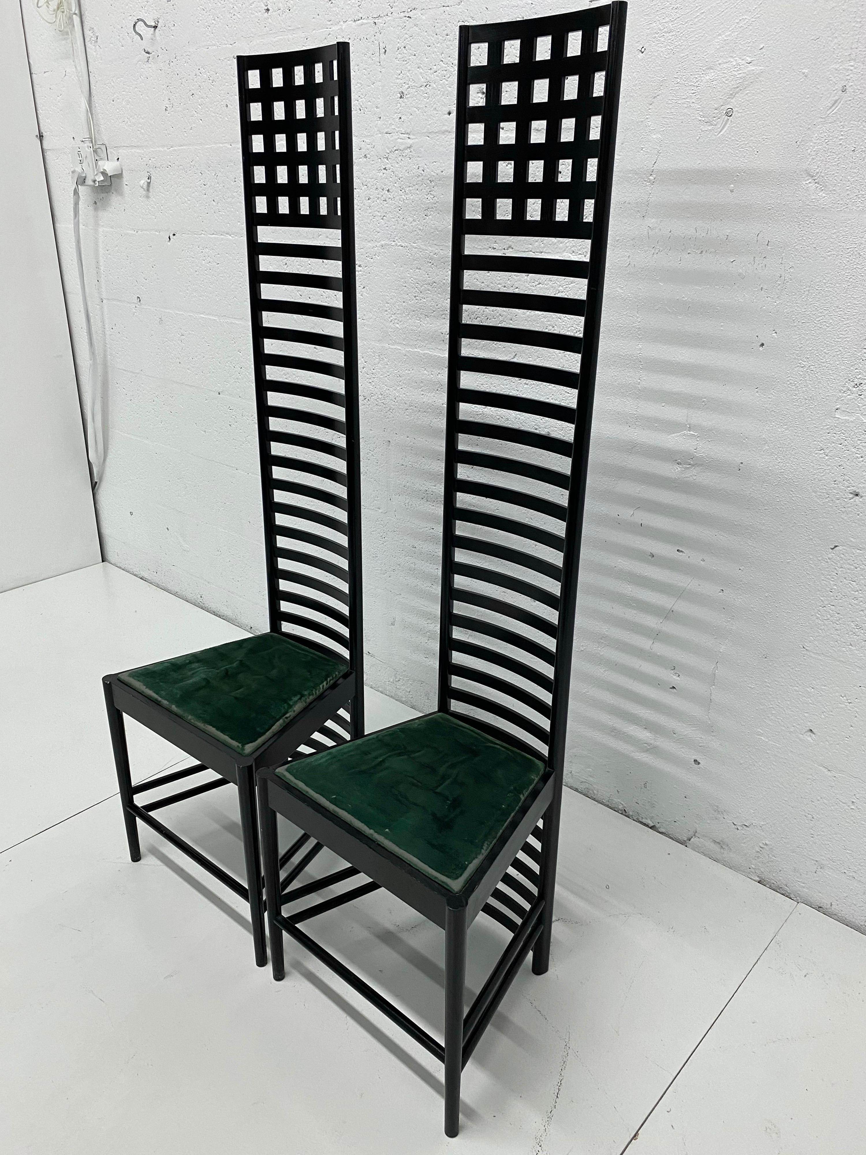 Pair of authentic Cassina production Hill House 1 chairs by Scottish designer Charles Rennie Mackintosh with original green velvet upholstery circa 1980s. The wood frame is original black-stain ash wood and shows wear.

This iconic chair reflects