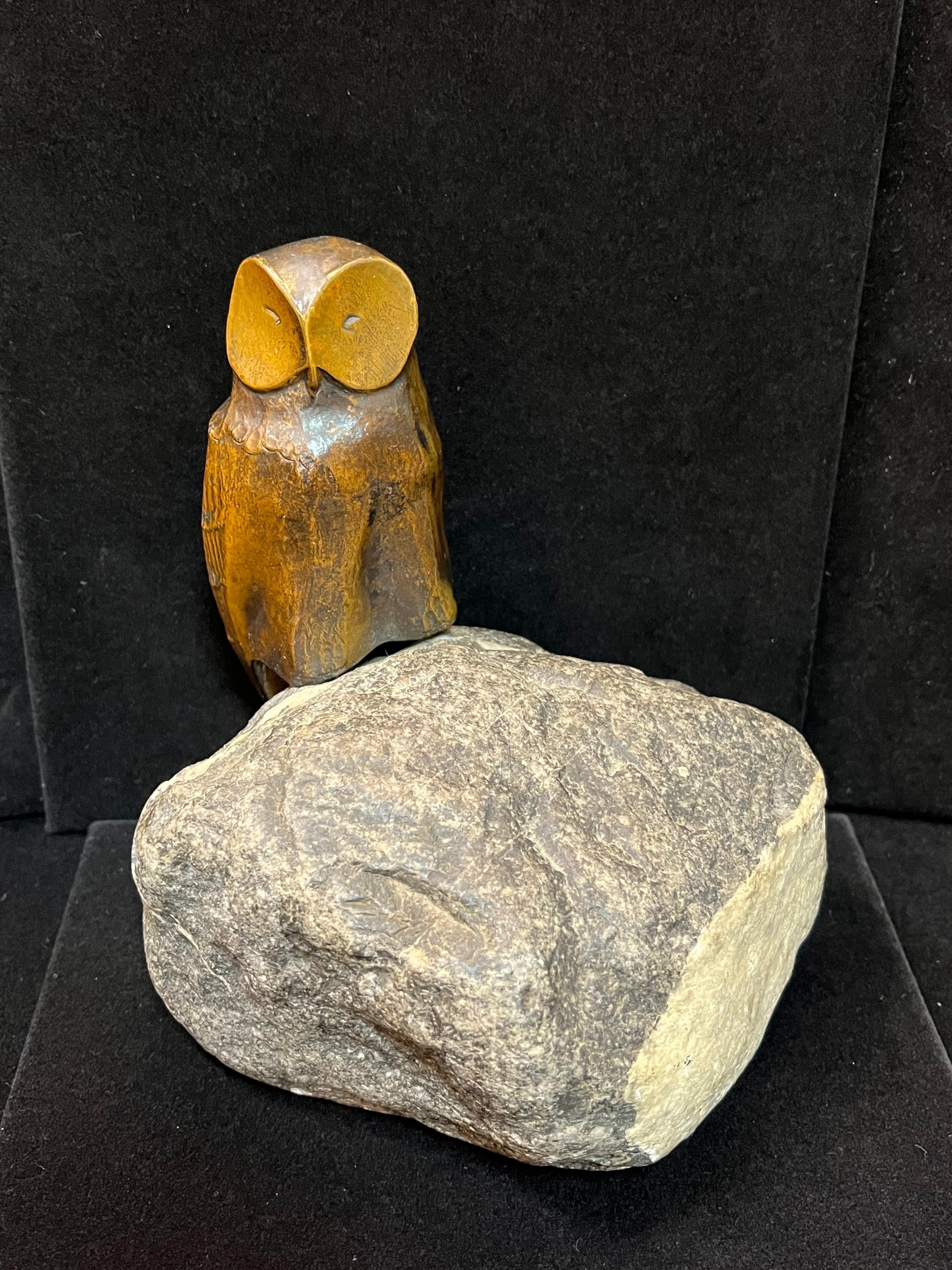A sculpted bronze Art Deco style owl perched on a natural stone by artist Charles Reussner (1886 - 1961). This wise old owl is on the side of the natural form rock, shades of stone with white contrast beautifully with the rich, warm patina of the