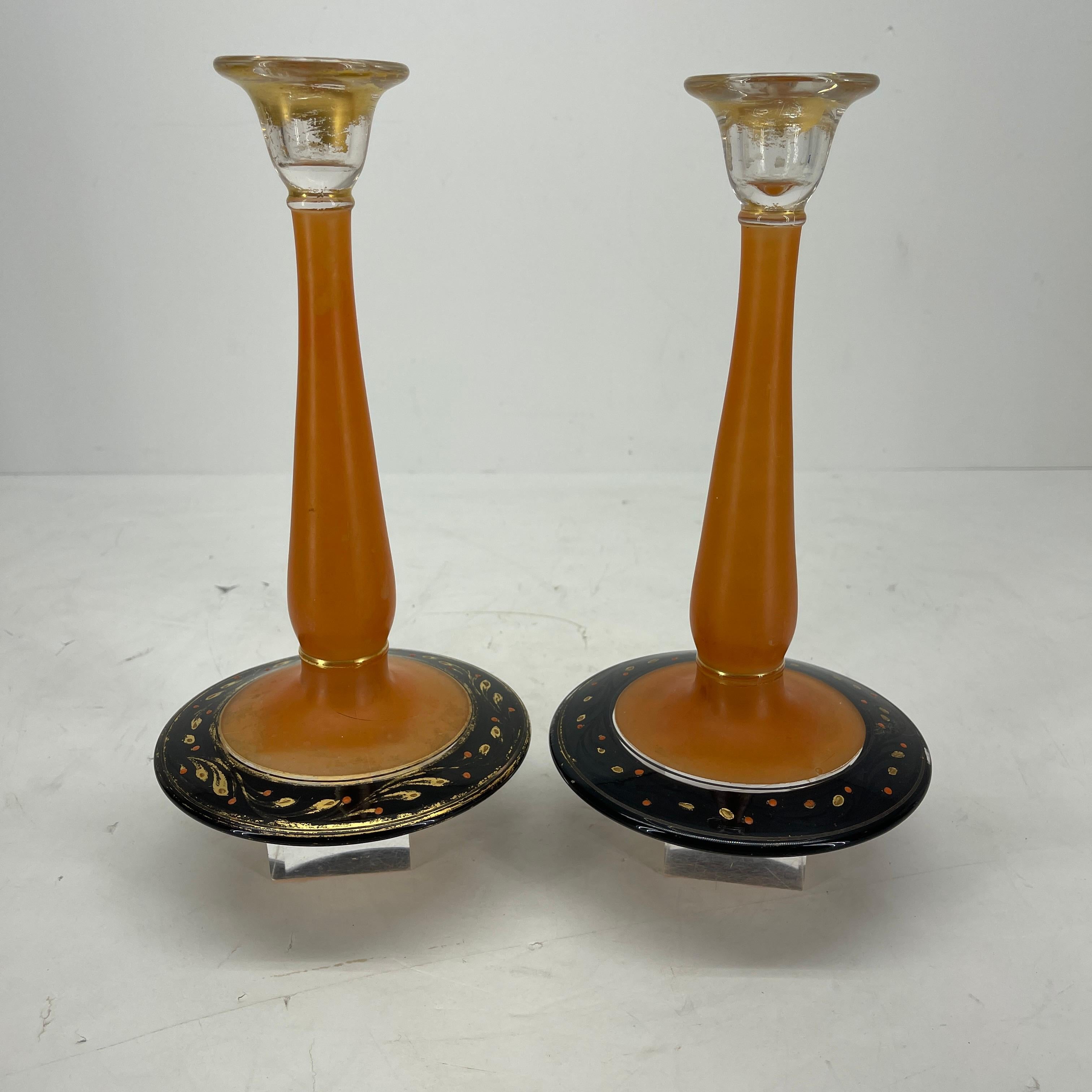 Art Deco orange and black pressed glass candlesticks in the manner of Charles Schneider. The candle holders have a delicate and beautiful etched design on the base and glow in the light. The candle holder bases do not match; each has its individual