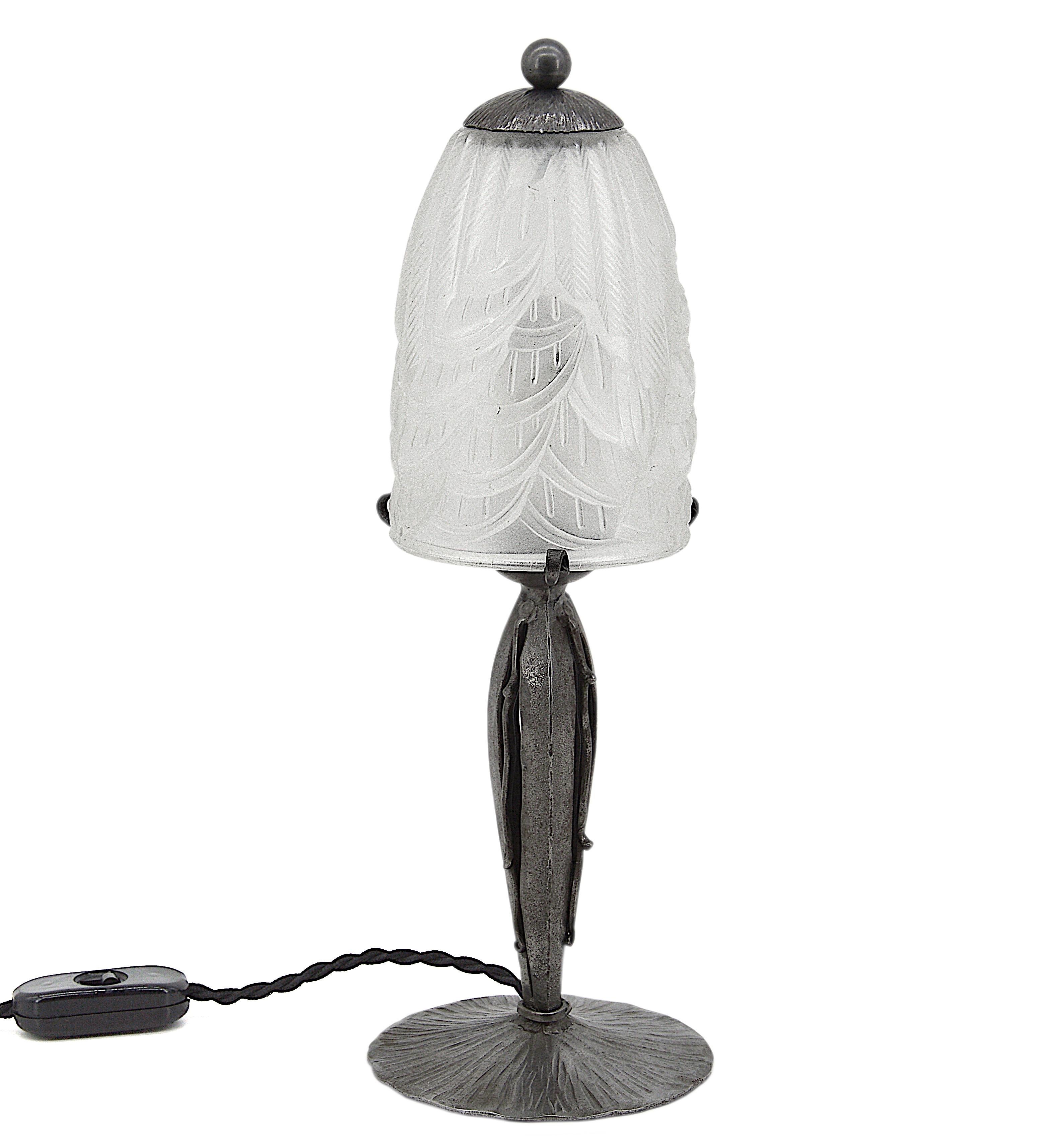 French Art Deco table lamp by Charles Schneider, Epinay-sur-Seine (Paris), France, 1920s. Molded glass shade with a stylized geometric pattern that comes hung at its original wrought iron base. Height 12.4