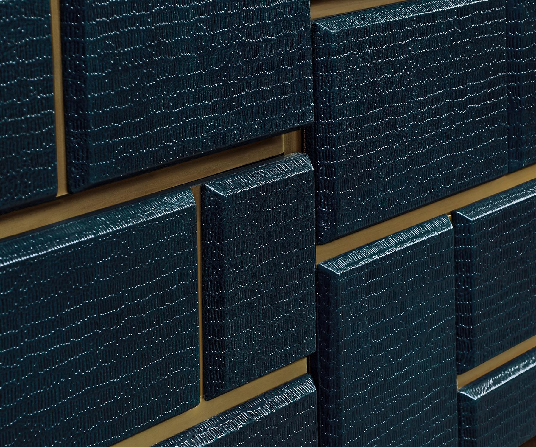 The Charles Serving Credenza merges bold geometry with refined materiality.

Its façade features embossed leather drawer fronts set in brass, forming a rhythmic play of depth and texture. A walnut body anchors the design, elevated by slender