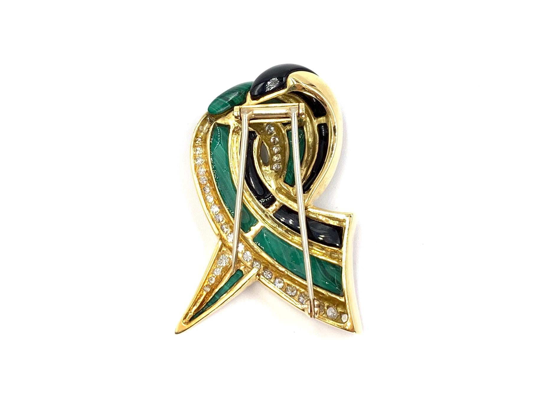 Incredibly well made by high jewelry designer, Charles Turi. This 18 karat yellow gold ribbon shaped brooch pin features beautiful striped genuine malachite, stark black polished carved onyx and exquisite white round brilliant diamonds. Diamond