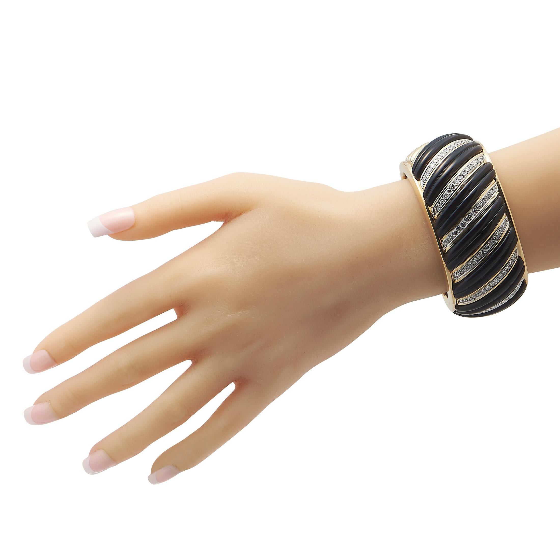 Holen Sie sich dieses Charles Turi Manschettenarmband, um Ihren Outfits ein gewagtes und dramatisches Element hinzuzufügen. Dieses Stück ist makellos aus 18 Karat Gelbgold gefertigt, mit gerippten Onyx-Platten, die zwischen diagonalen Reihen von