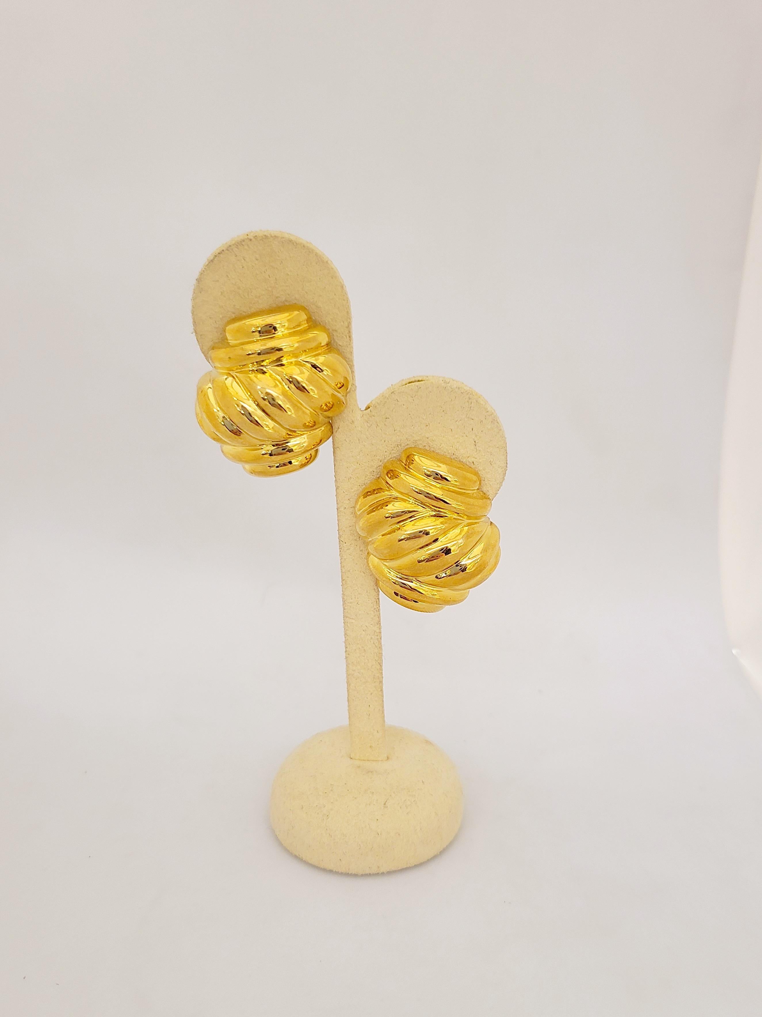 Designed by the legendary Charles Turi Jewelry Company. These classic 18 karat yellow gold earrings are designed in a hi polished yellow gold twist motif. The earrings are pierced with a french clip and can be adjusted to clip on. The earrings