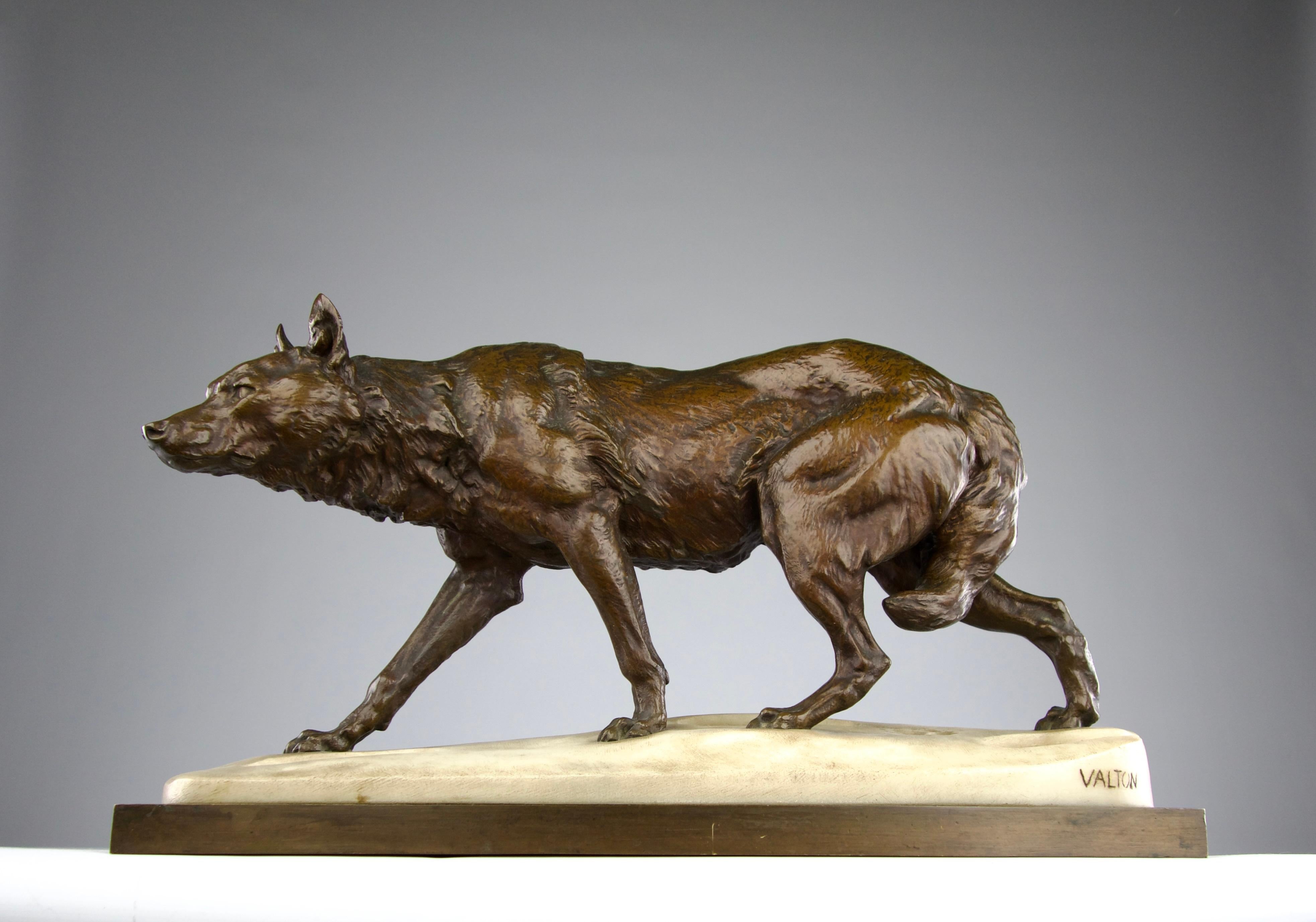 Superb wolf sculpture in bronze and marble flooring simulating snow by the artist Charles Valton. The wolf dutifully follows an adventurer whose steps are carved into the snow. A beautifully executed work with exquisite detailing and patina on the