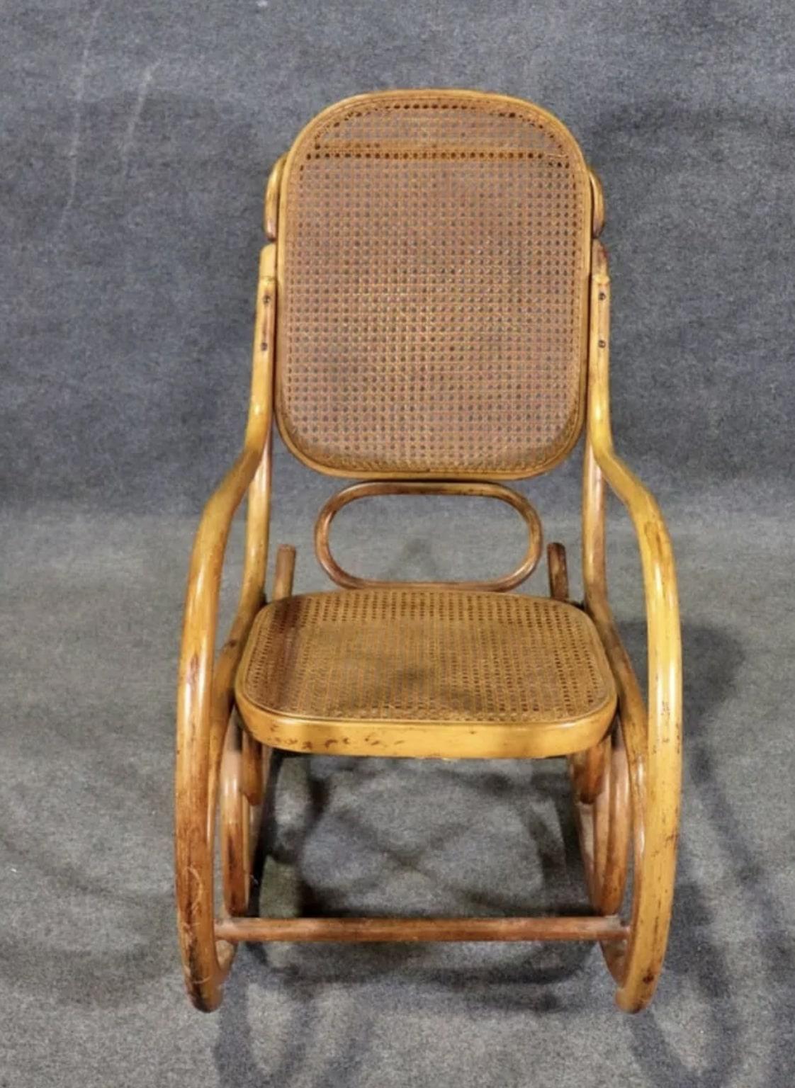 Classic rocking chair by Thonet for Stending Co. Beautiful bentwood lines throughout this rocking chair, completed with caning seat and back.
Please confirm location NY or NJ