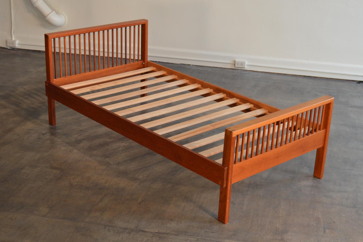 Charles Webb single cherrywood bed frame. Finger-jointed on the upper corners. Slat base. Sticker label. Disassembles to ends, rails, and slats. Made in Massachusetts. The company produced furniture from the 1960s-1990s.