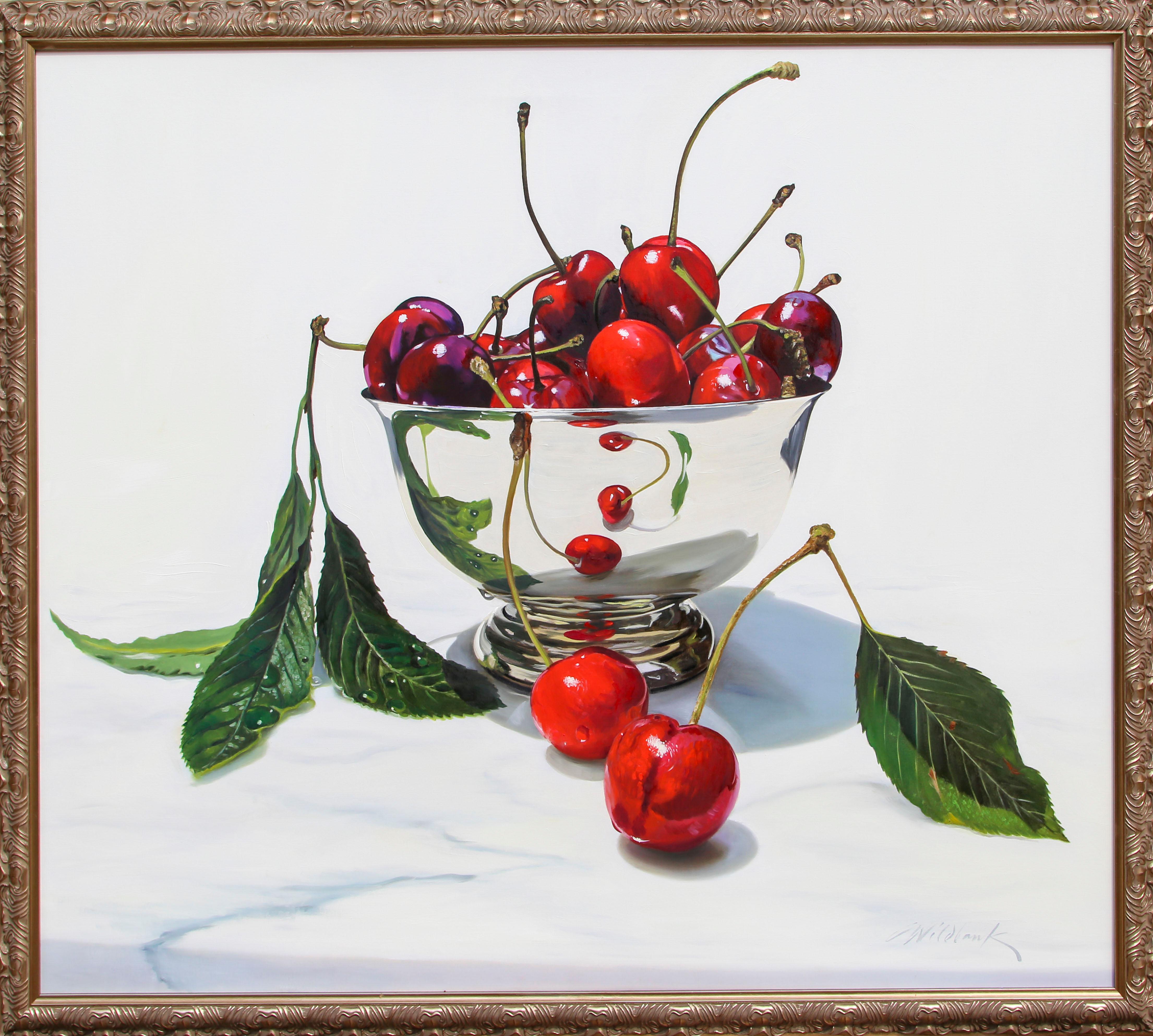 A bright, photorealistic still-life painting of a silver bowl full of cherries, perched atop a white marble surface. The artist has taken immaculate care to preserve the shiny aspects of the fruit and bowl, and even captured it in the waxy surface