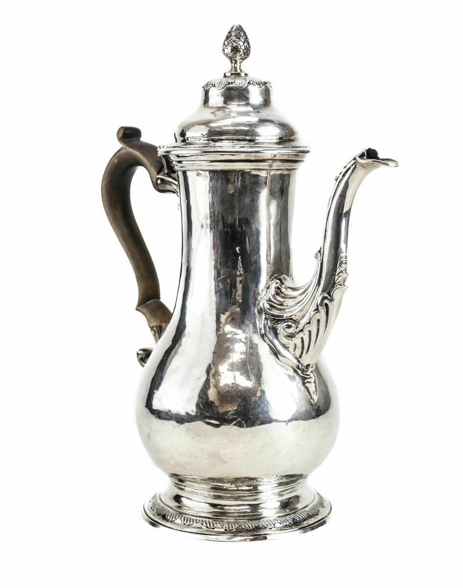 Harles Wright sterling silver coffee pot London George III, 1769. The coffee pot has a wooden handle and an acorn floret. The beak of the coffee pot is hunted to look like a bird in the hand. Manufacturer's hallmarks and money on the underside.