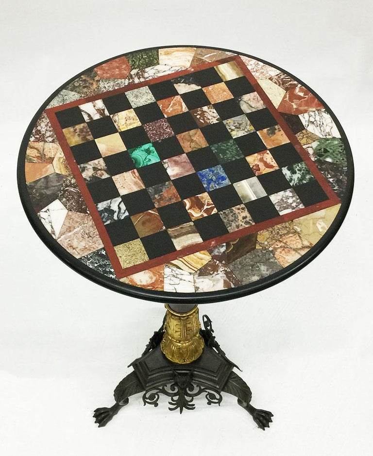Charles X, 19th century chess table, bronze gilded inlaid with marble and stones

A bronze gilded chess table in Charels X style with a bronze gilded tripod base with a loose blade of 46 diagonal with inlaid marble and stones, such as malachite