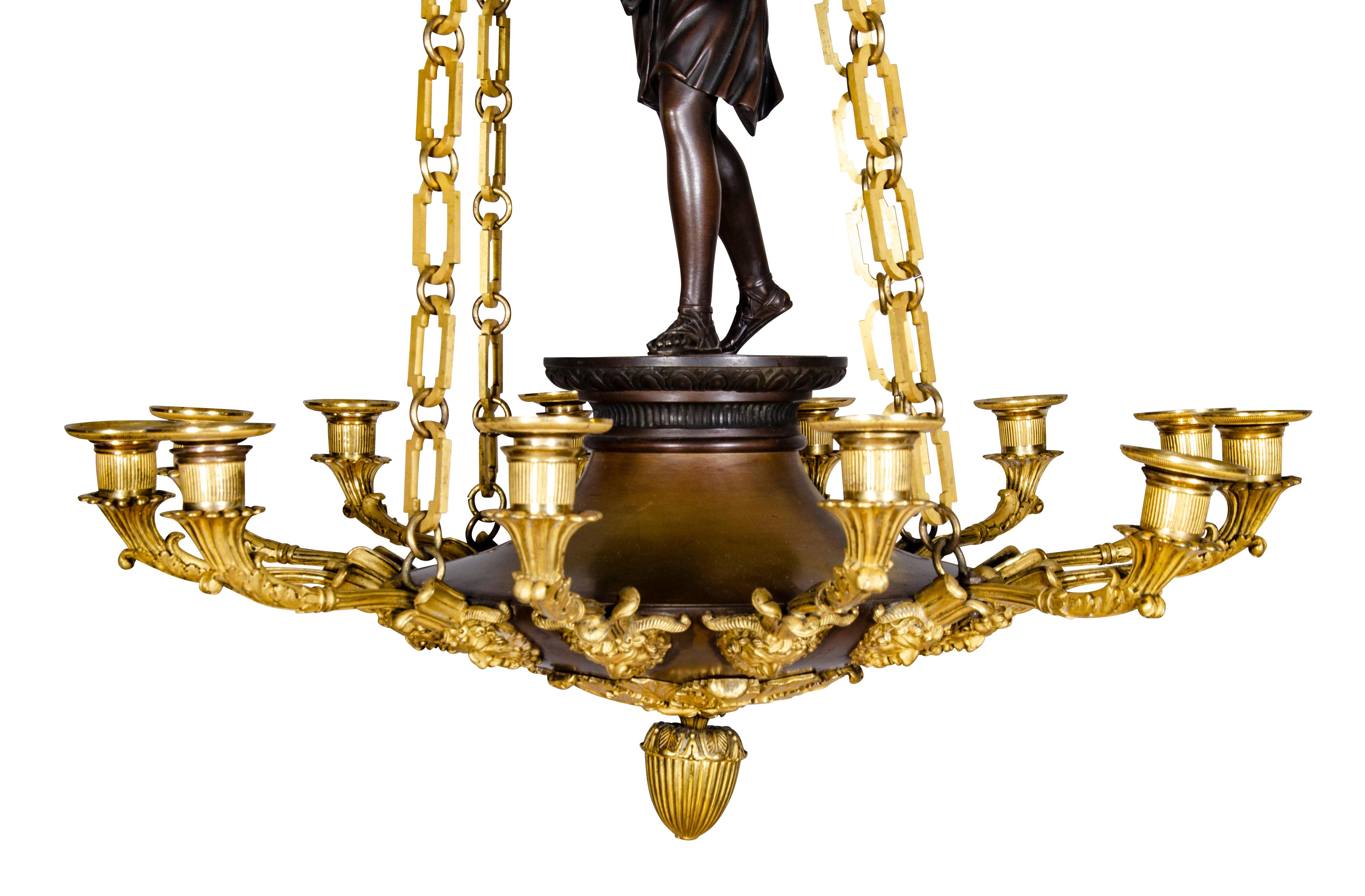 Finest quality with a ceiling cap of cast bronze original to the piece with four square link gilt bronze chains supporting a circular bowl form twelve light fixture with a figure of a standing Diana. The underside with finely cast satyr heads and