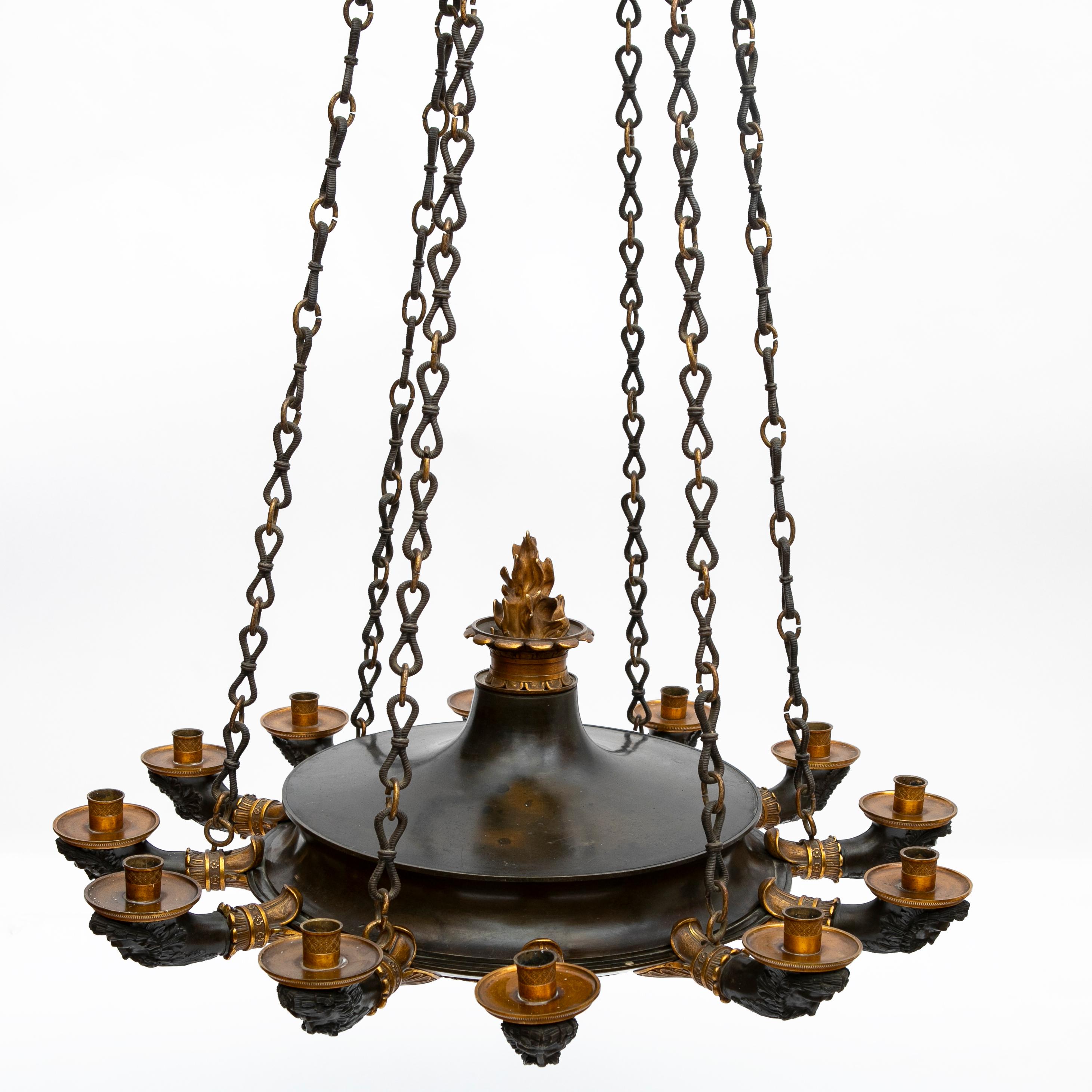 A large and very impressive 12 arm Charles X chandelier.
Made in France during the early 19th century in patinated bronze and ormulu. Rich in details with a coronet adorned with panther heads and chains hanging down to the chandelier that has twelve
