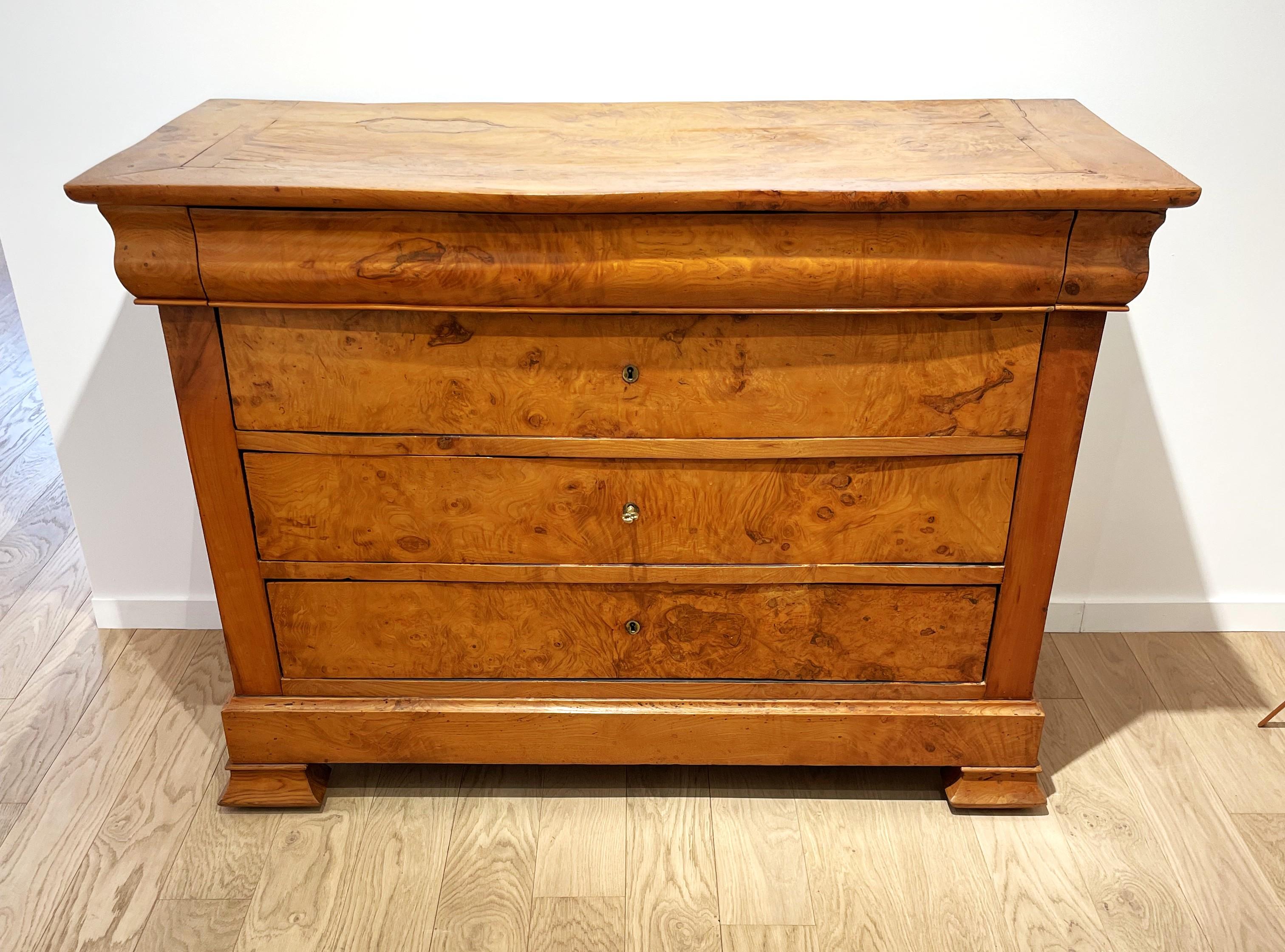 Elm burl chest of drawers from the Charles X period circa 1830, brass lock entries. This beautiful chest of drawers goes very well with mid 20th century furniture by bringing a touch of classism. It is its simple shapes and the blondness of the rich