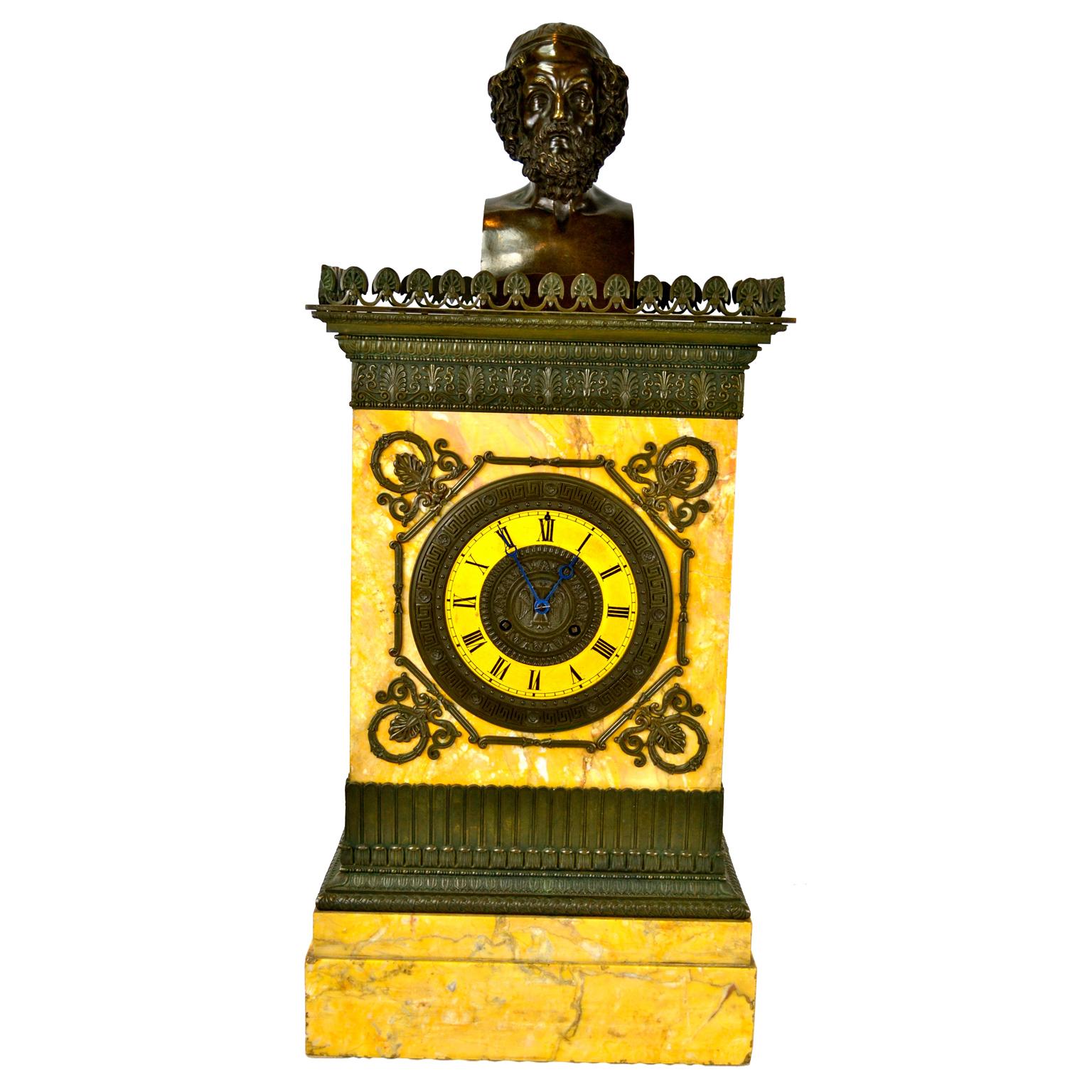 A large Charles X Sienna marble and patinated bronze clock and matching candelabra. The architectural style case made of Sienna marble has a patinated bronze gallery and lower bronze stylized moulding to the stepped lower marble base. A bronze bust