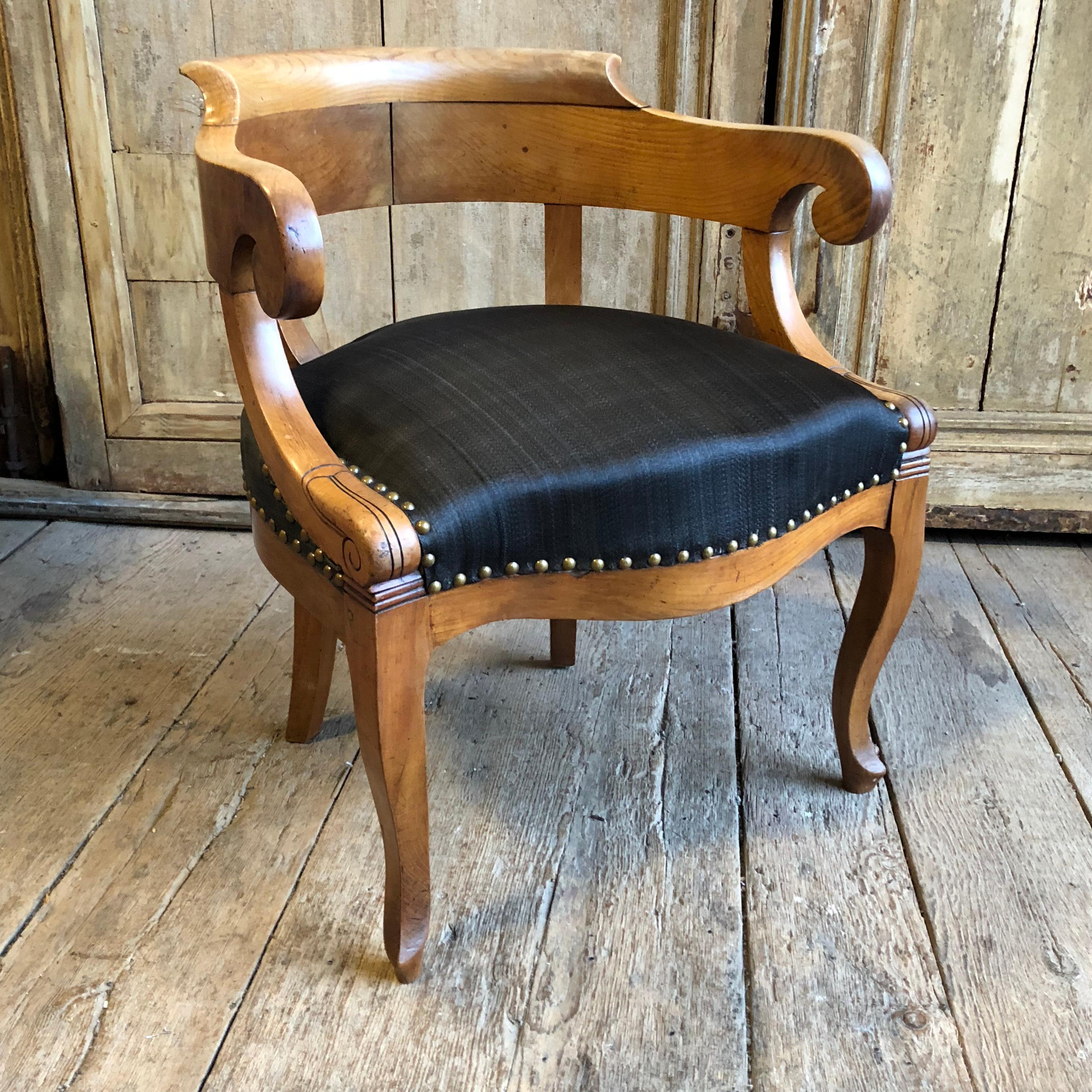 A Charles X period “Fauteuil de bureau” with a yoke-back, low arms and upholstered seat on cabriole legs, in blonde fruitwood, circa 1820.  The Charles X style, also known as “Restauration Period Style” and it’s use of “bois Claire” or light woods,