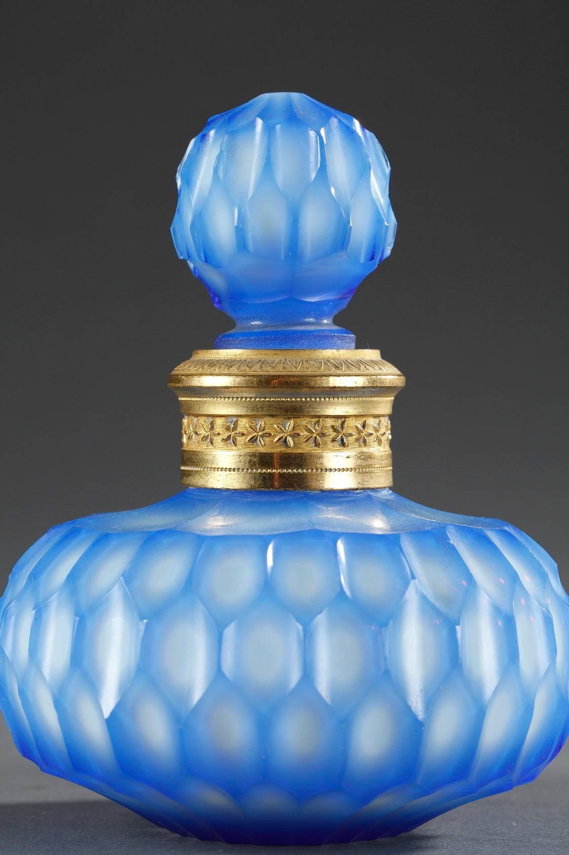 Flacon de parfum avec son bouchon en forme de boule en opaline blanche et bleue, décorée de motifs hexagonaux. Le collier est orné d'un anneau en bronze doré, magnifiquement gravé de feuilles d'eau et d'étoiles,

 vers 1820
Dimension : L 3,9 po x