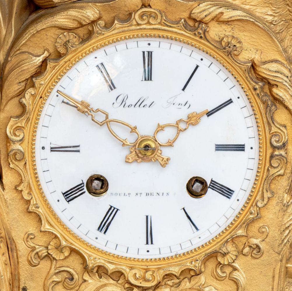 Charles X Gilt Bronze Figural Clock, circa 1830, depicting Marguerite, Queen of France, standing beside circular enamel dial, the movement strike on bell, signed 