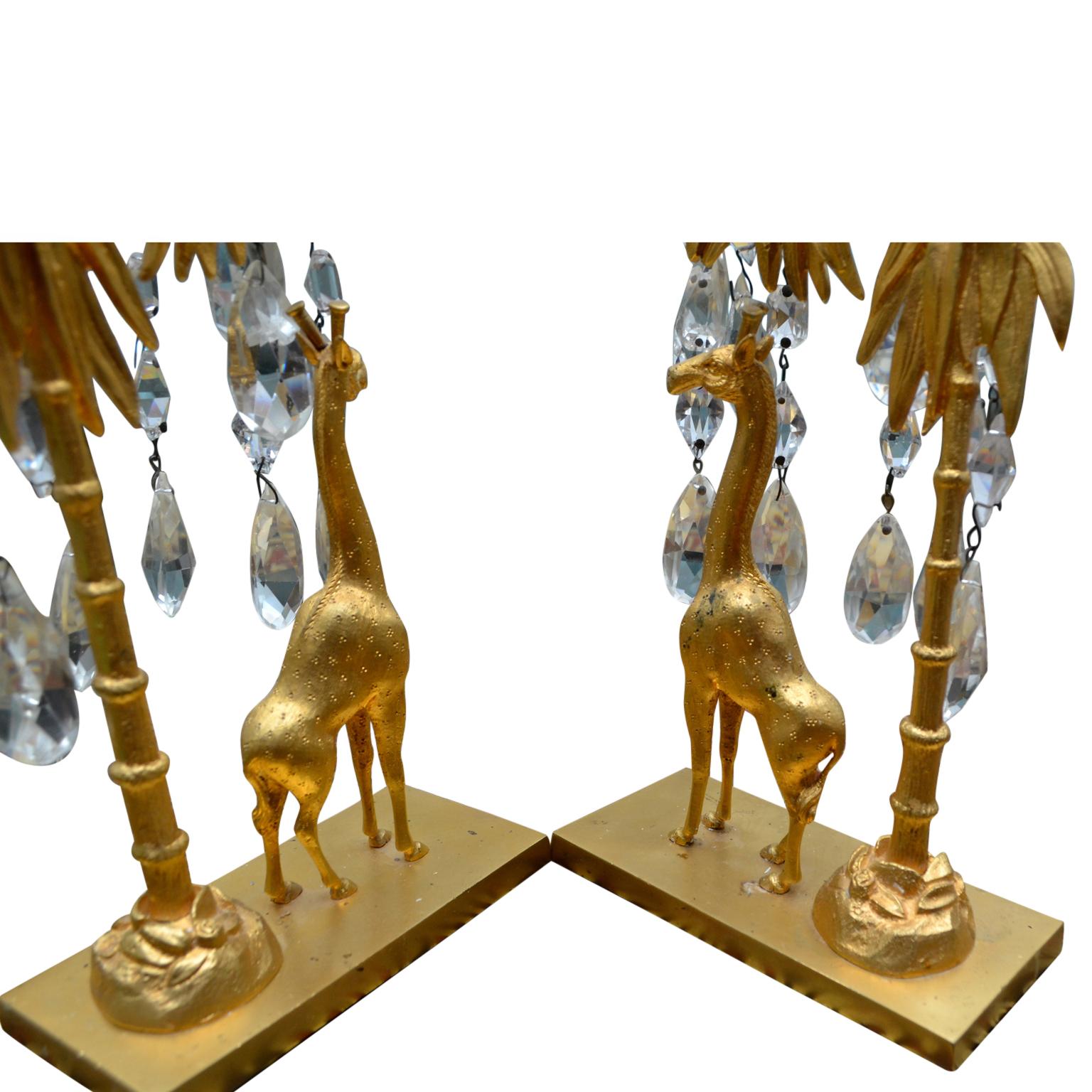 A pair of period Charles X candlesticks in gilded bronze and cut crystal. The candlesticks feature a gilt bronze giraffe standing under a 'palm tree' from which hang various sized and various shapes of finely cut crystal. The single candle nozzle is
