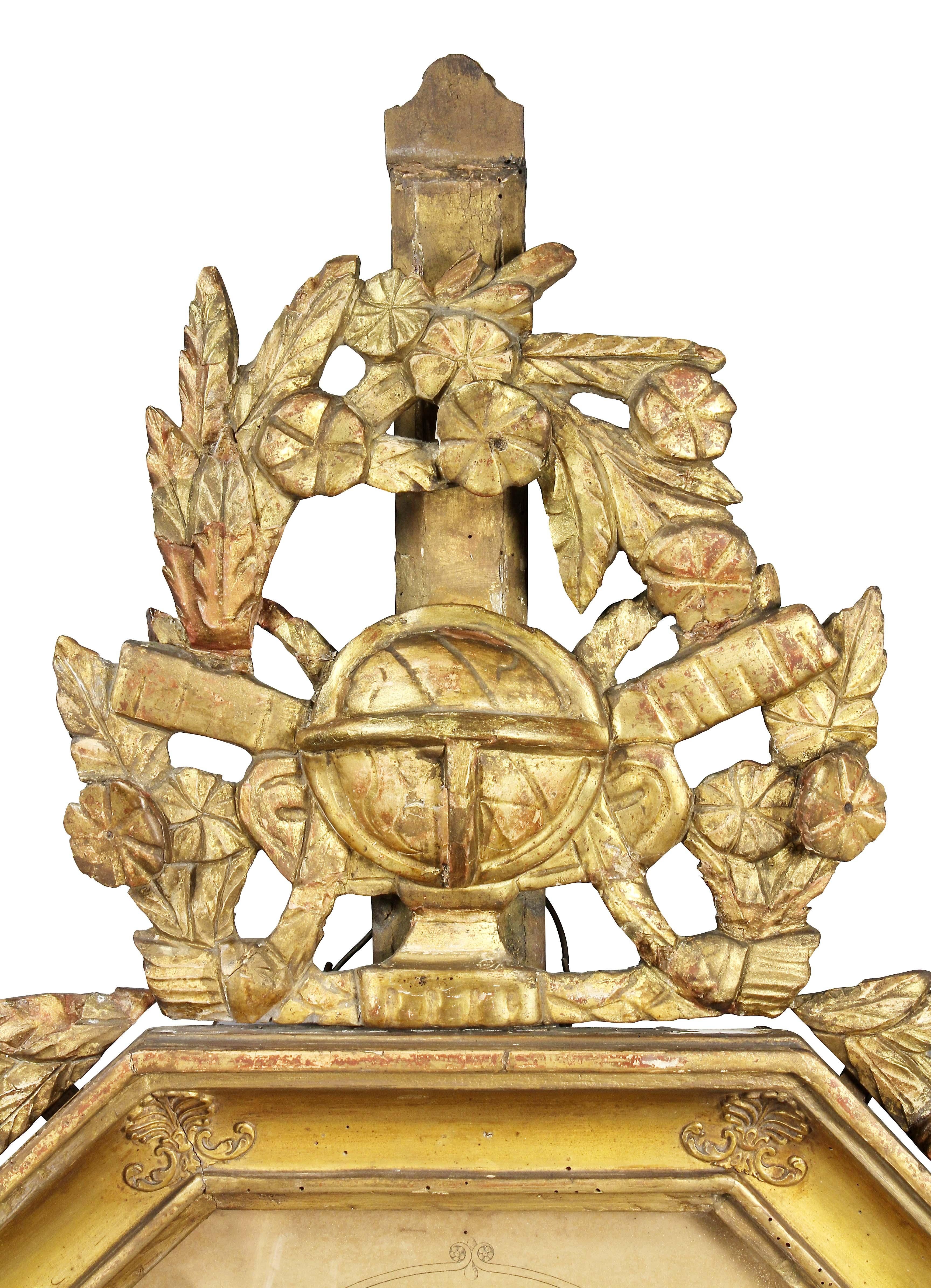 With leaf and floral crest with central orb over an octagonal glass and a paper dial set in a conforming frame.