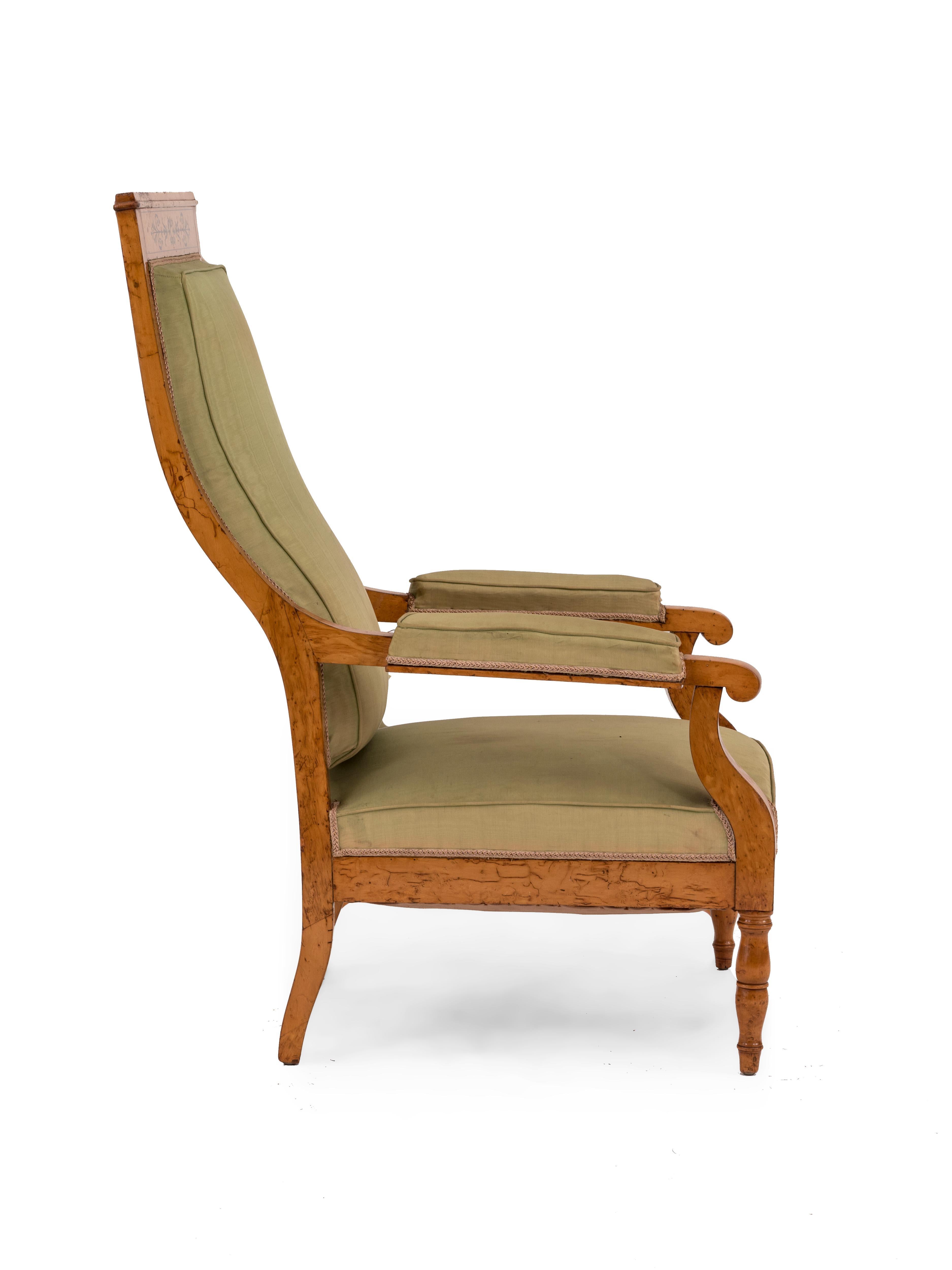 French Charles X maple armchair featuring a sloped high back, scrolling arms, and decorative filigree inlay.