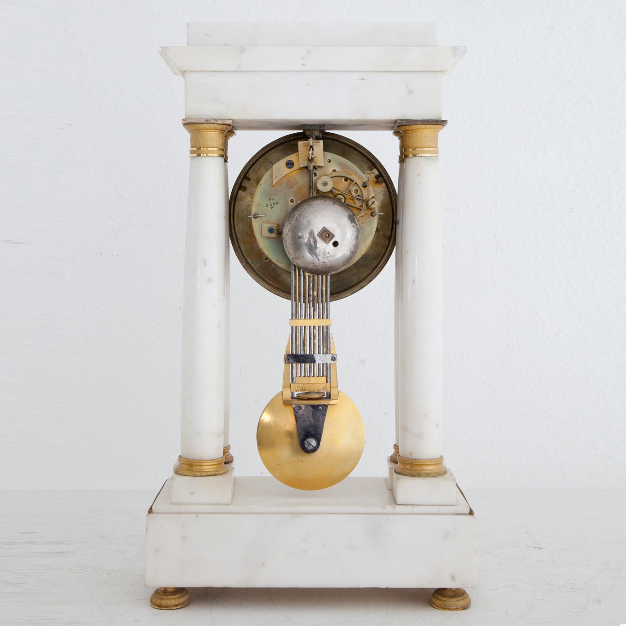French pendule clock, the base, pedestal and columns are out of white marble. The silvered clockface with Roman numerals is inscribed Jeannest à Paris.