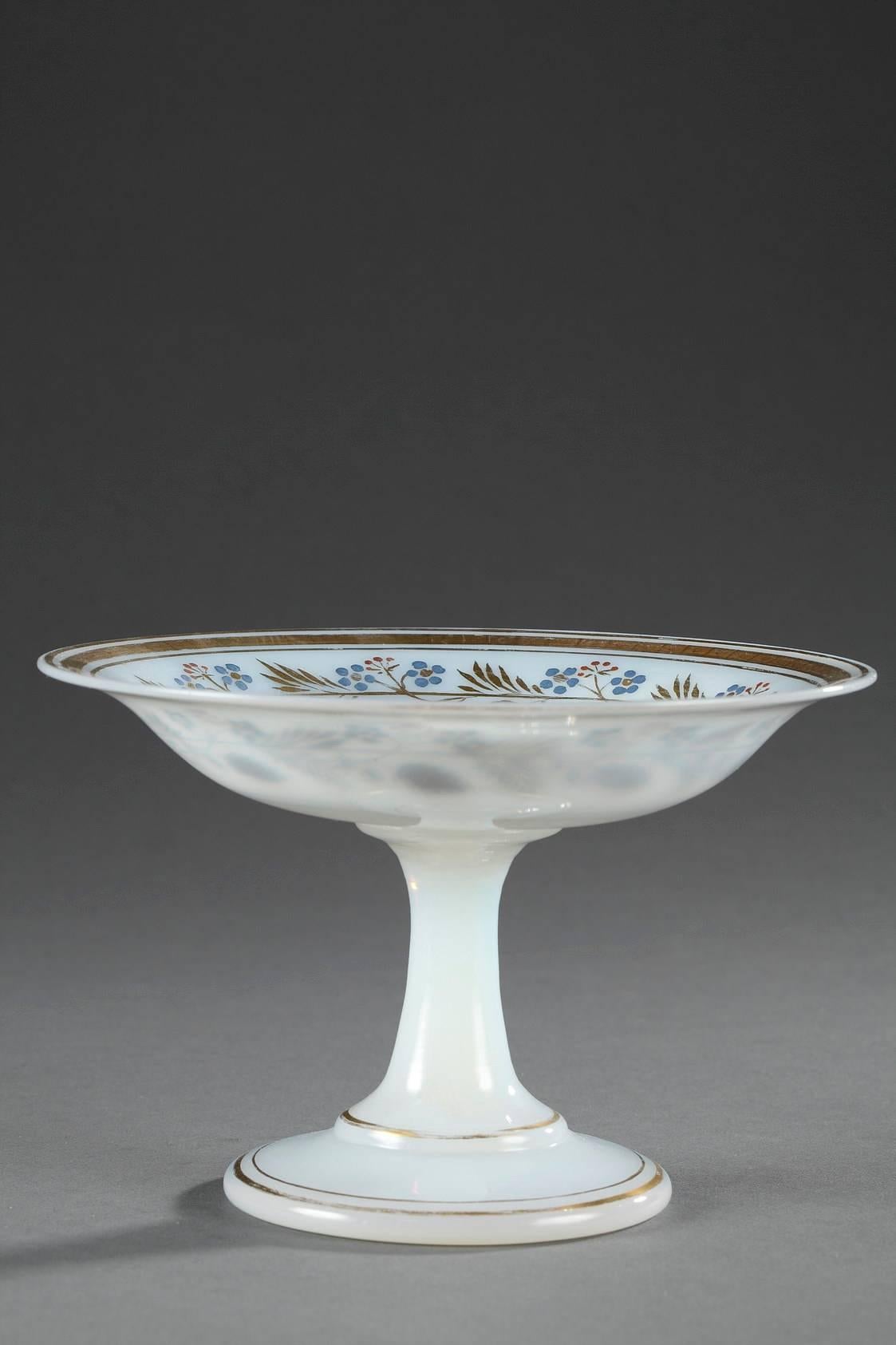 White Opaline crystal cup on a raised foot accented with gilt stripes. A gilded and multicolored ring of anemones and forget-me-nots adorns the interior of the cup, and floral pattern marks its center. The piece was produced by the Jean-Baptiste