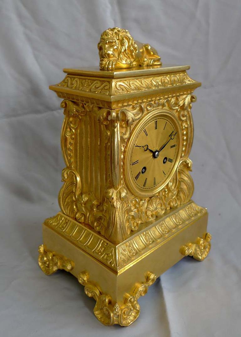 A French antique Charles X period ormolu mantel clock. The ormolu in excellent original condition and the case of very heavy, dense construction. All parts are beautifully cast. The lion to the top of the case very well cast and with good finishing