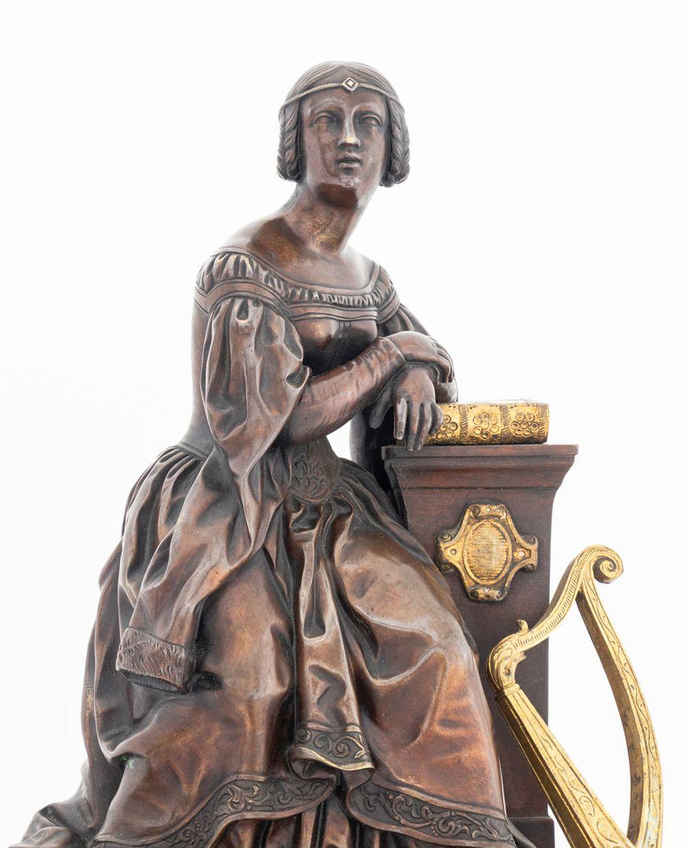Charles X Patinated Bronze and Brass Mounted Verde Antico Marble Figural Clock, circa 1830, surmounted by a seated woman resting on a pedestal with a harp, the circular silver dial, the movement strike on bell, on a stepped foliate scrolled plinth