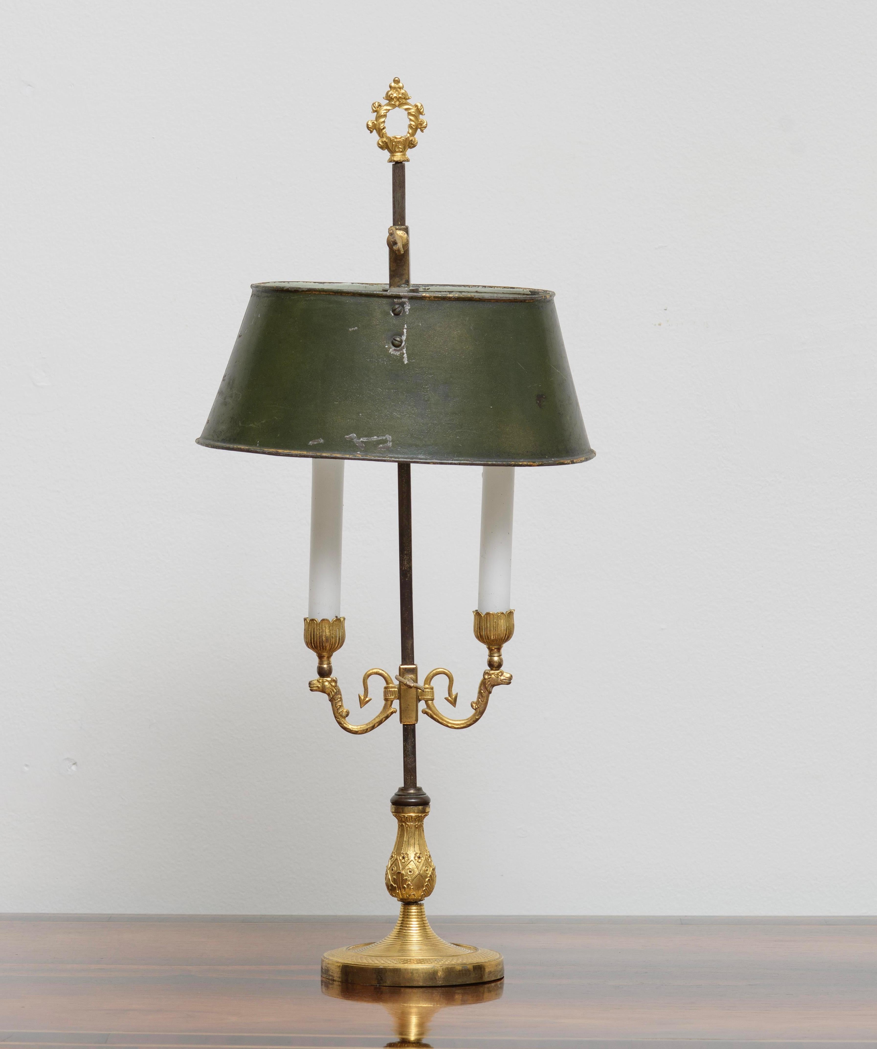 This Charles X period bouillotte lamp, dating from circa 1825, features a gilded bronze base that exemplifies the opulent design of early 19th-century France. With its elegantly curved arms supporting two candle arms, this lamp marries functionality