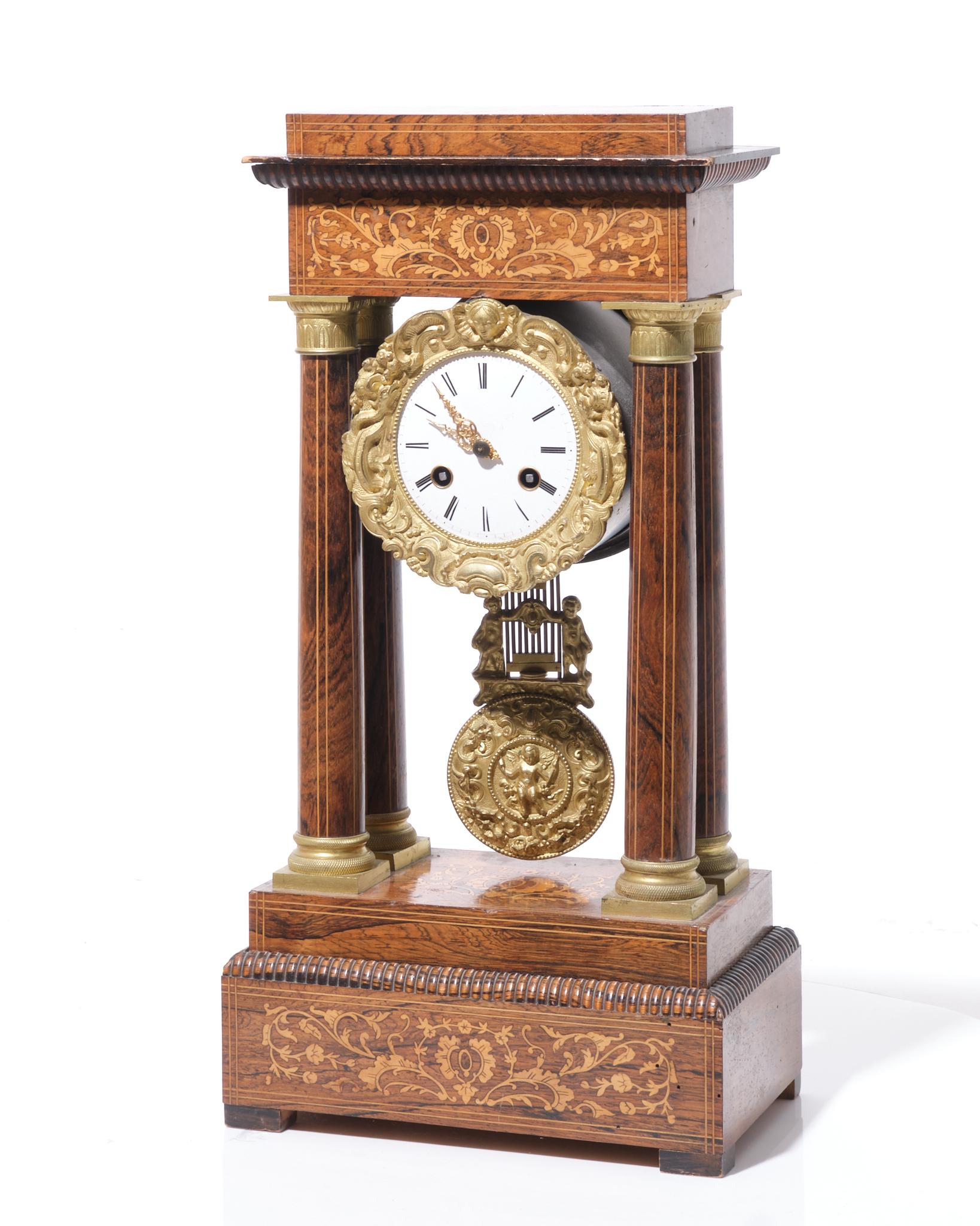 Charles X Portico Mantel Clock, dating from the early 19th century. The clock features a rosewood body intricately inlaid with delicate fillets and foliage scrolls. The portico design, characterized by four columns supporting an entablature, frames