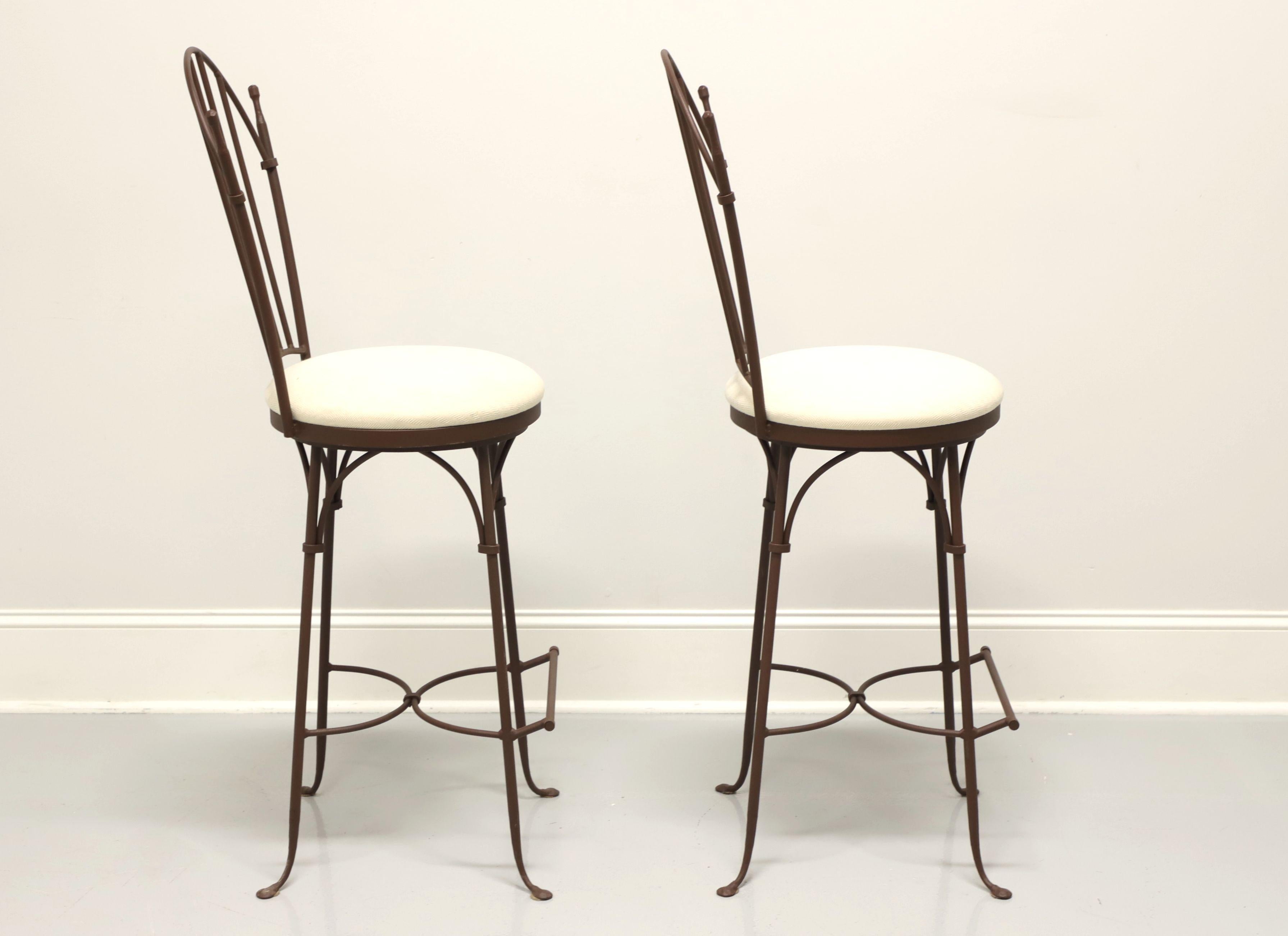 A pair of Contemporary style bar stools by Charleston Forge. Wrought iron with a Shaker arch back, cream colored fabric upholstered round seats that swivel, arced stretchers and bar foot rest. Made in Boone, North Carolina, USA, in the early 21st