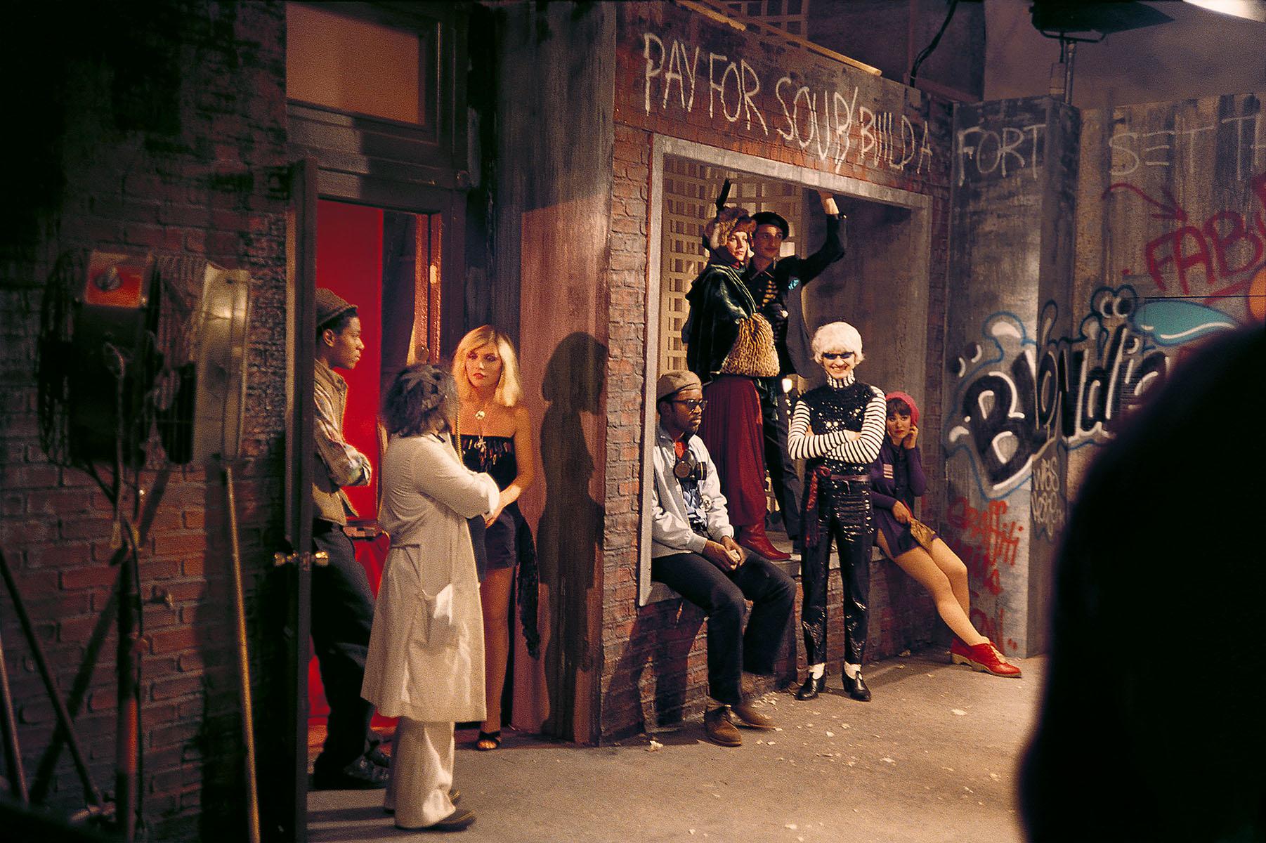 Charlie Ahearn, "Rapture" 1981 :
Une rare photographie historique de Jean-Michel Basquiat, Debbie Harry, Fab 5 Freddy prise par le directeur de Wild Style, Charlie Ahearn, sur le plateau de tournage de "Rapture" de Blondie. Cette œuvre a été