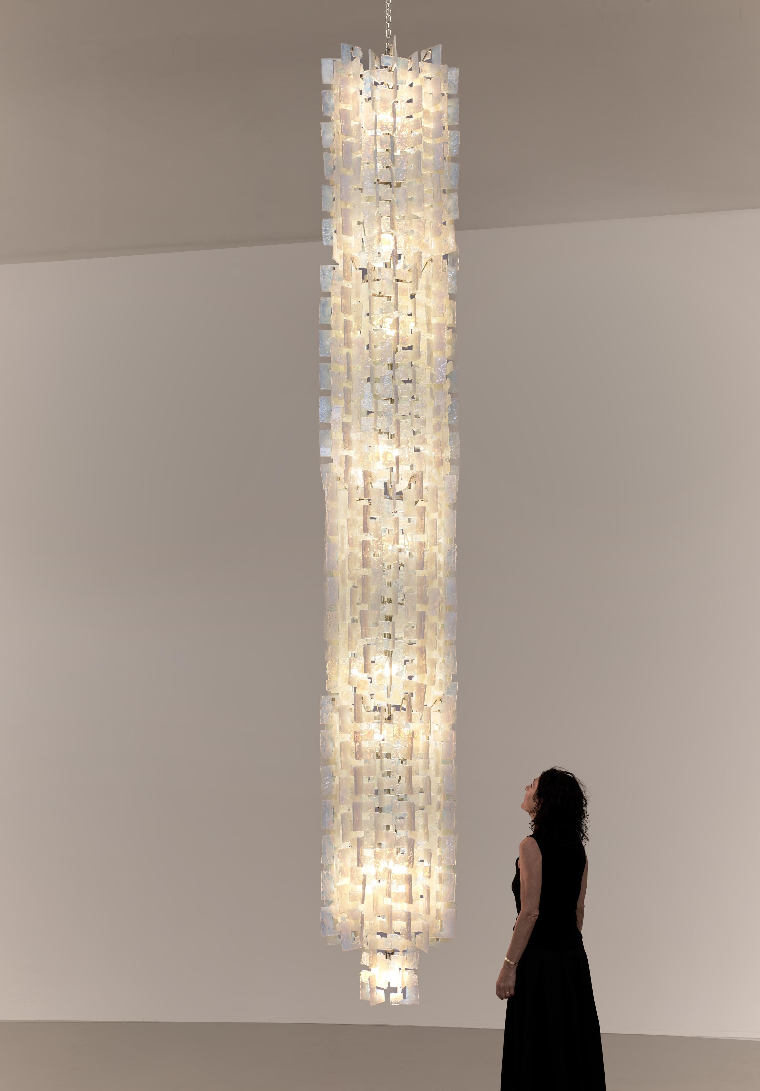 Dieser Kronleuchter wurde in den 1970er Jahren von Carlo Nason entworfen und von Mazzega in Murano, Italien, hergestellt. Es besteht aus zahlreichen opalisierenden Glaselementen, von denen jedes die Form eines C-Gliedes hat und so gestaltet ist,