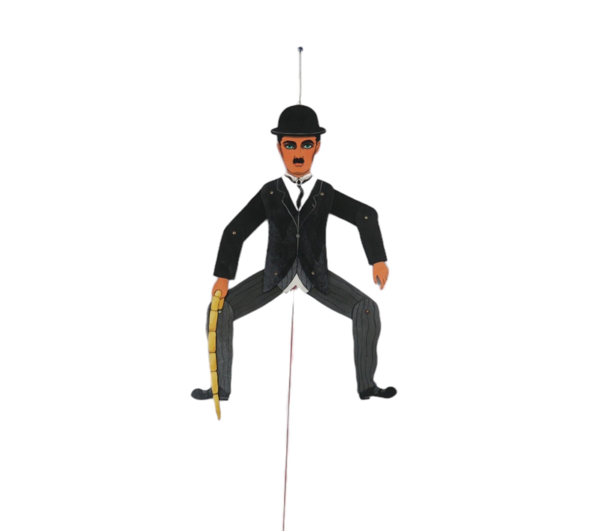 A Charlie Chaplin hanging pullstring flat puppet. Pull the string and make him dance! The bowler hat and cane were Charlie Chaplin's trademarks and indispensable props to his famous Tramp guise. Chaplin recalled how the costume induced the