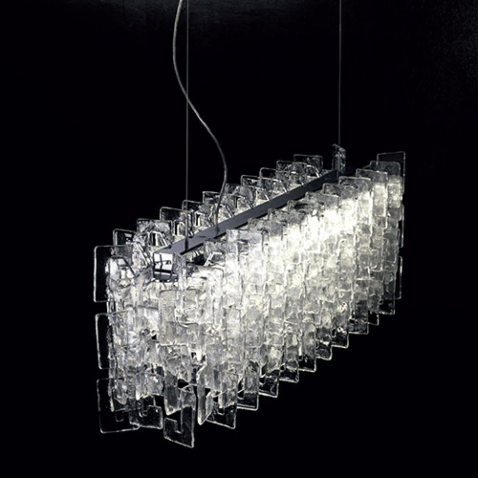 Lampada a sospensione Charlie CHASOML1 di Mazzega 1946
Dimensioni: L 113 x P 25 x H 150 cm.
Materiali: Cromo lucido. 
Diffusore: Cristallo trasparente. 
Peso: 033 Kg. 

Le radici di Mazzega1946 affondano a Murano, terra di maestri vetrai che ancora