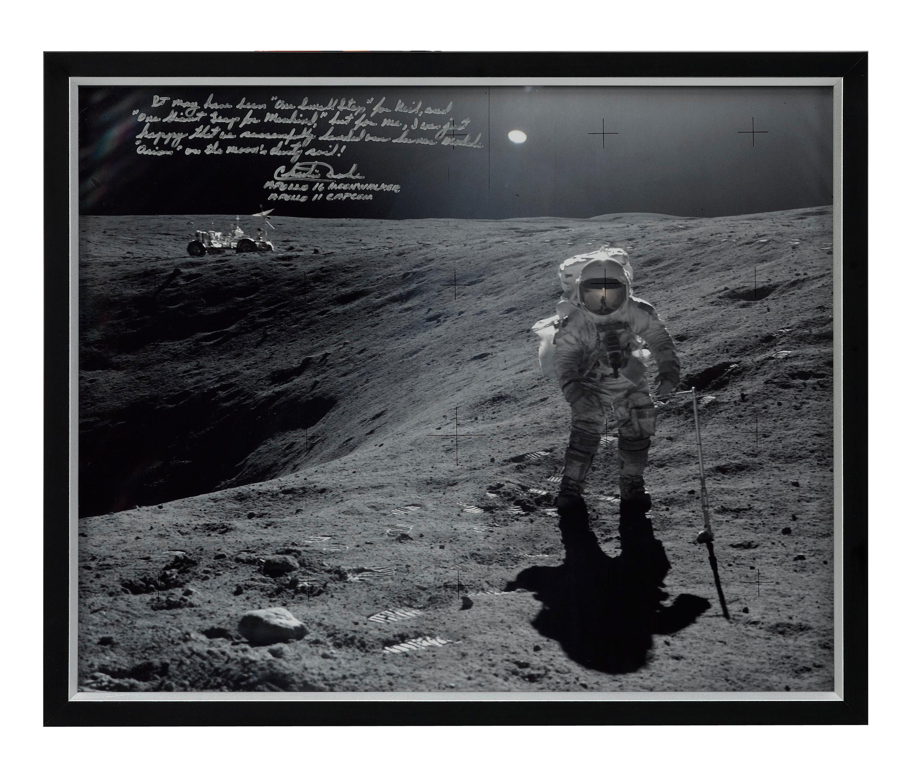 Presented is an Apollo 16 mission photograph, signed and inscribed by Apollo 16 moonwalker Charlie Duke. The photograph shows Duke collecting lunar samples next to Plum Crater on the Moon. The photograph is inscribed in felt-tip gold ink and reads,