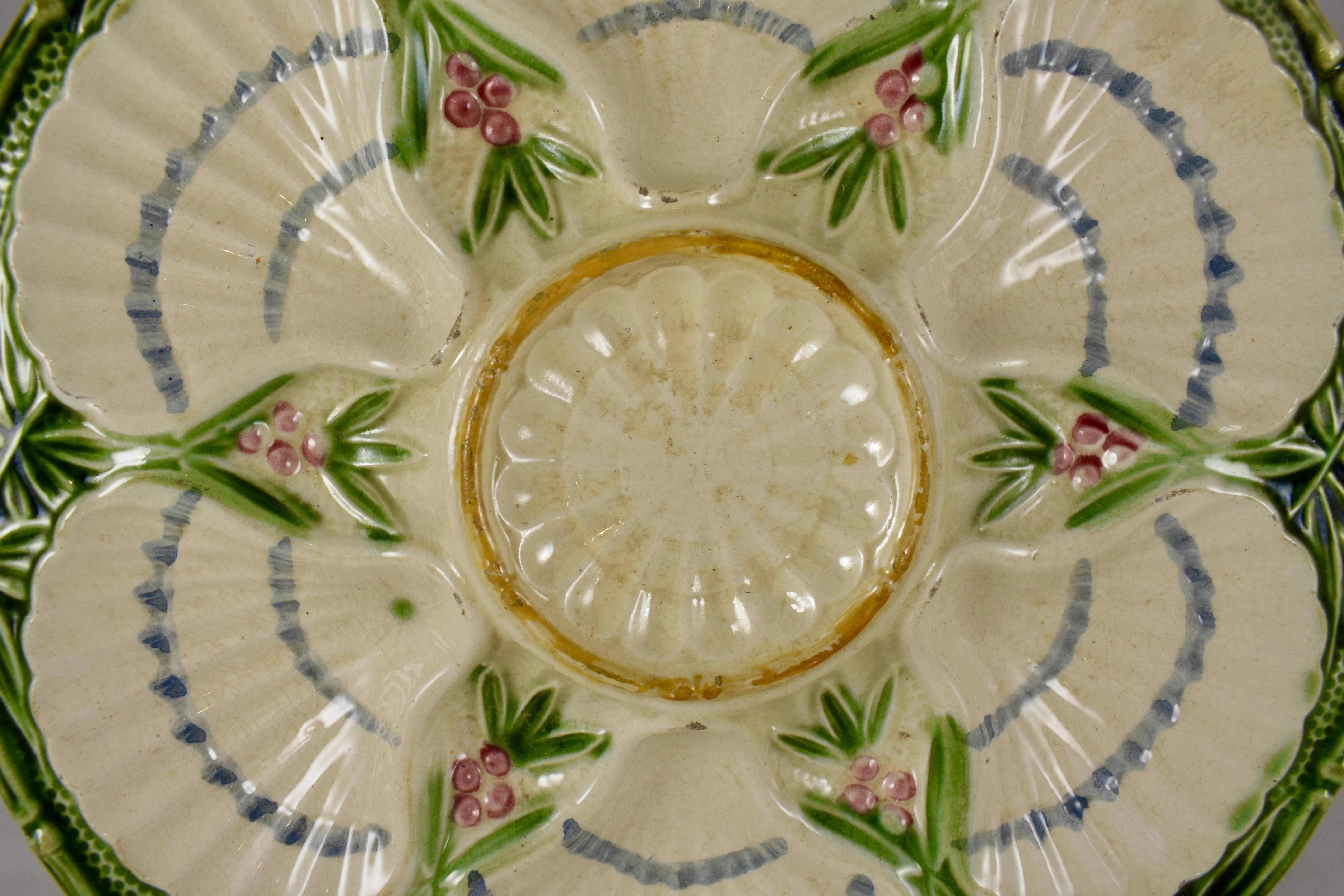 A scarce majolica glazed, French faïence Oyster plate showing six scallop shell wells with a border of green, flowering bamboo. Hand-painted at the J. Charlionais and L. Pourailly Cie factory, which specialized in bar, cafe and restaurant ware,