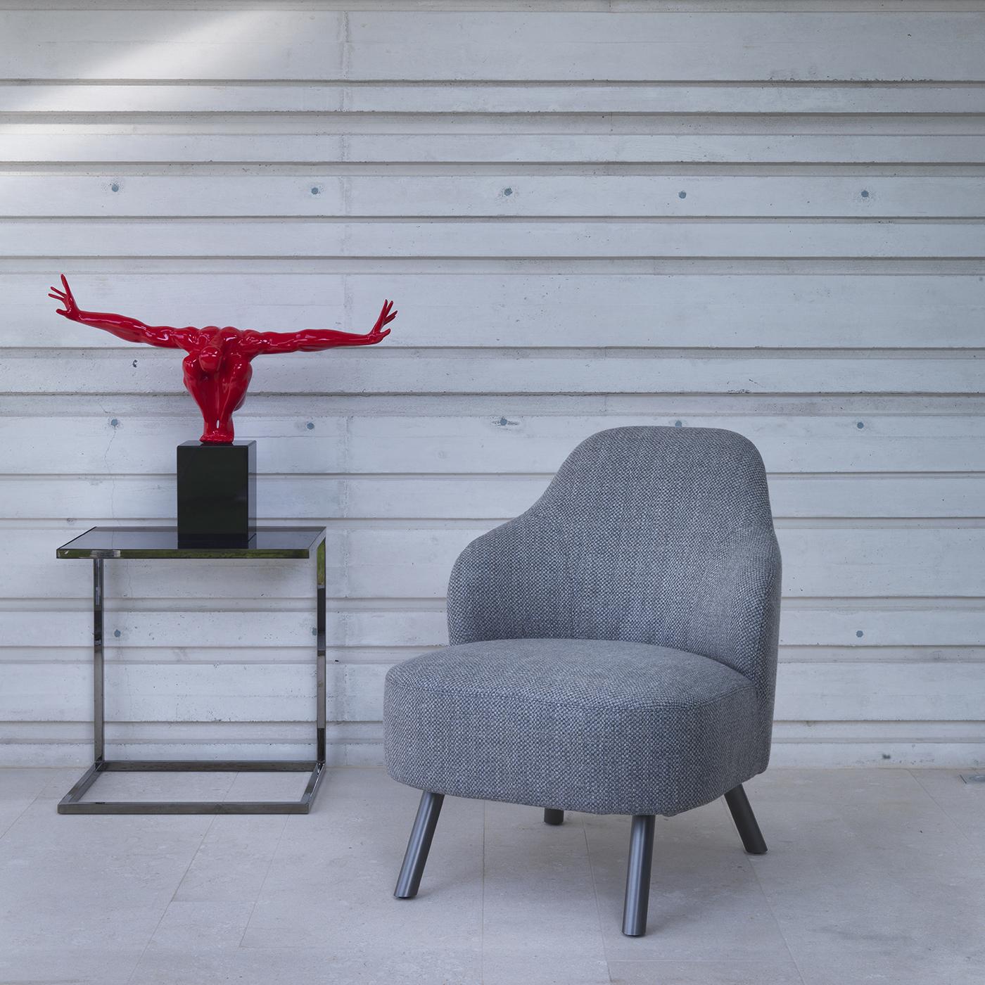 This chair features soft, sinuous lines and a large wraparound back without armrests. Its seat is covered in rigid polyurethane foam and memory foam, while its plywood back sports rigid polyurethane foam and protective fabric, which is not