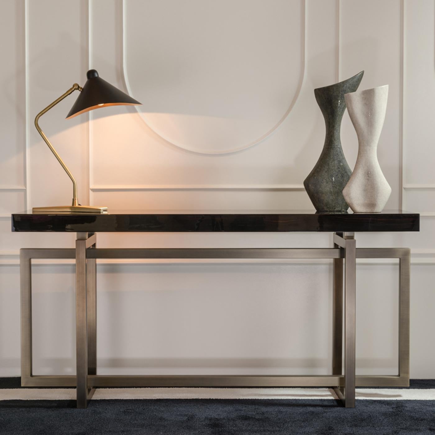 Stunning from all sides, this sculptural console boasts a unique design that can be showcased as a statement piece at the center of a large room or loft space to create visual and spatial division. The 7 cm-thick rectangular top of glossy Macassar
