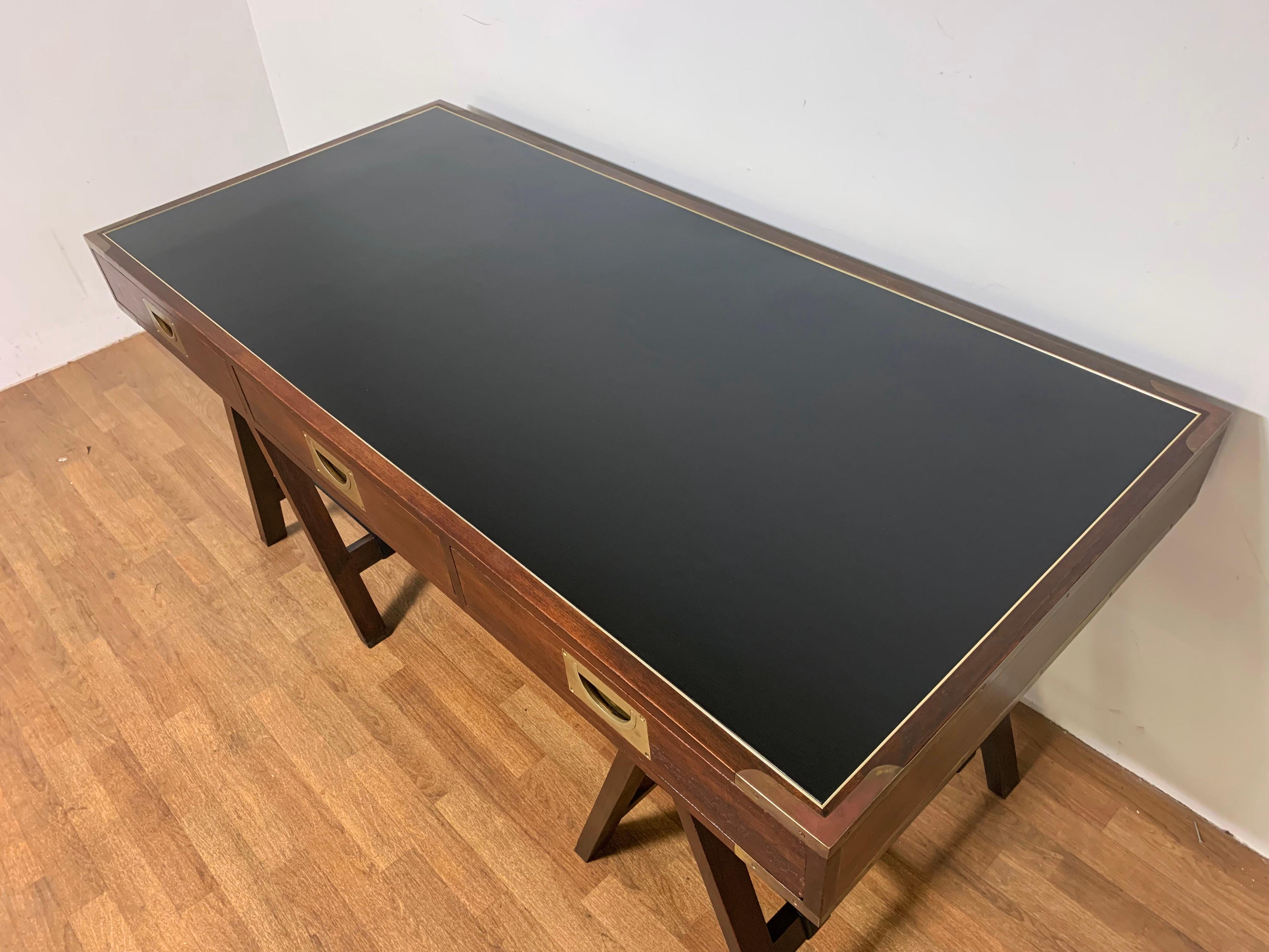 Mahogany campaign desk from the legendary Hong Kong shop of the antiques dealer Charlotte Horstmann, ca. 1960s. Features a brass banded leather surface, corner straps and flush mount handles.