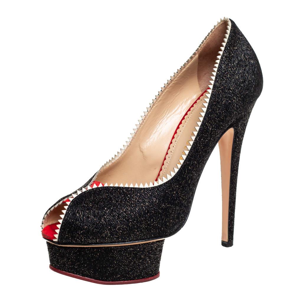 Ces escarpins de Charlotte Olympia sont un véritable coup de foudre ! Ces beautés noires sont délicatement fabriquées à partir de paillettes et de cuir verni et sont conçues pour plaire aux yeux de ceux qui les regardent. Ils arborent des bordures