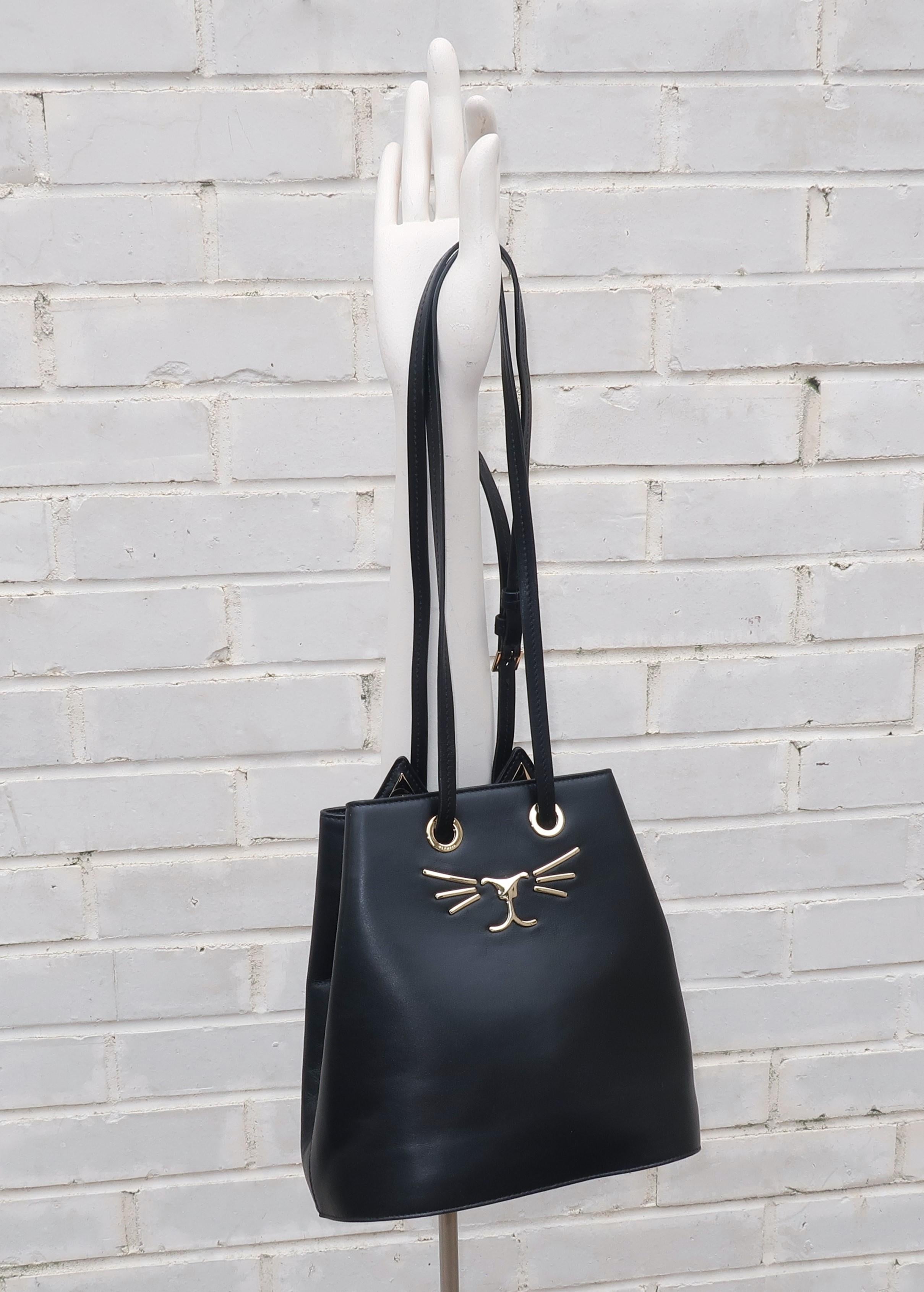 Meow!!!  This Charlotte Olympia black leather handbag is functional and fabulous with a personality driven feline 'kitty' face in shiny brass metal accents and ear silhouettes.  The bucket body and long shoulder strap make this an easy carry and a
